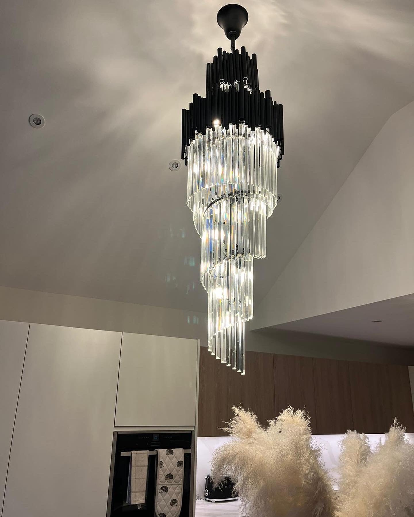 Tiered crystal staircase chandelier creating a dramatic focal point in modern interior
