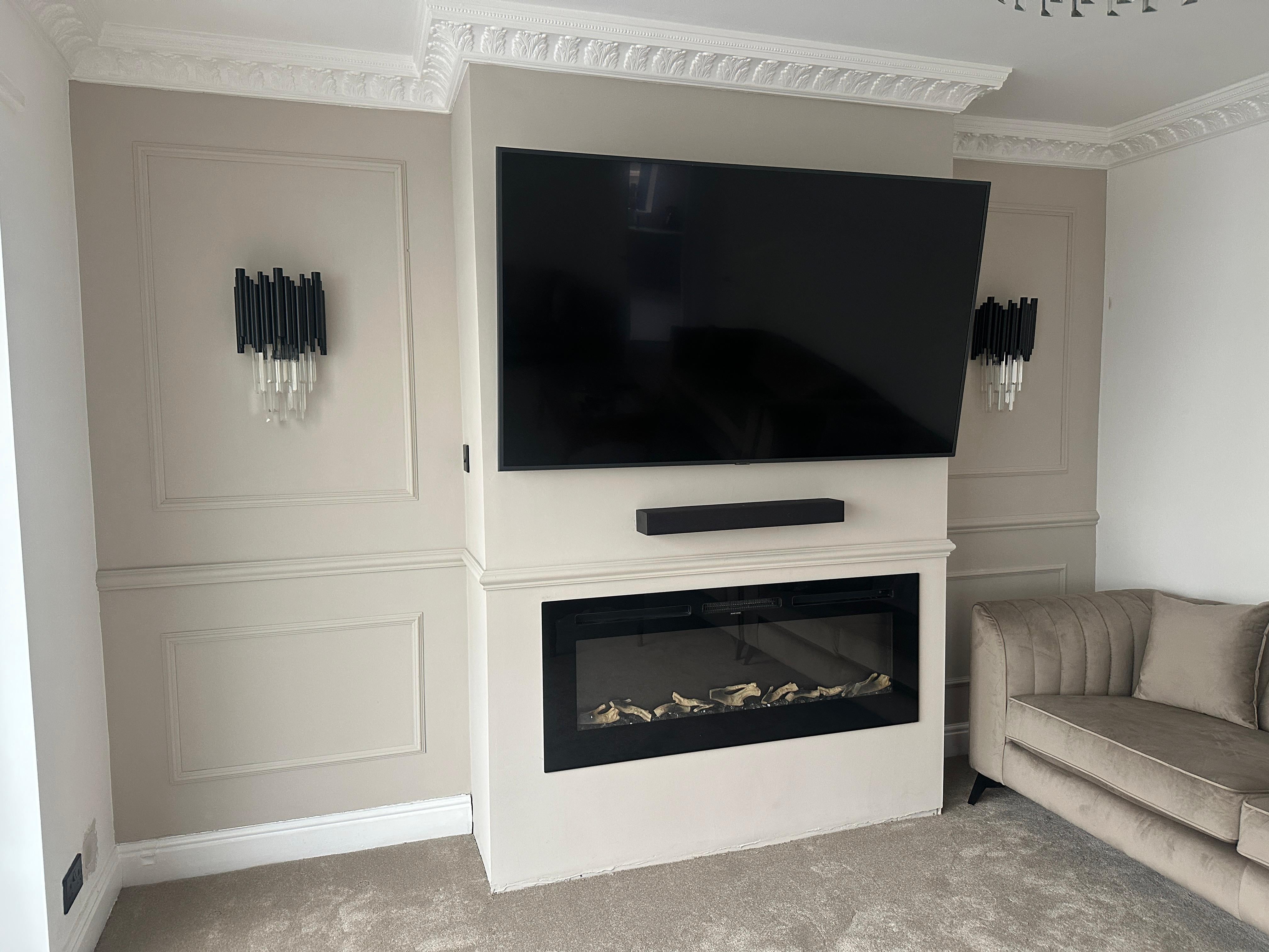 Gotham wall lights installed either side of a fireplace in a contemporary luxury living room