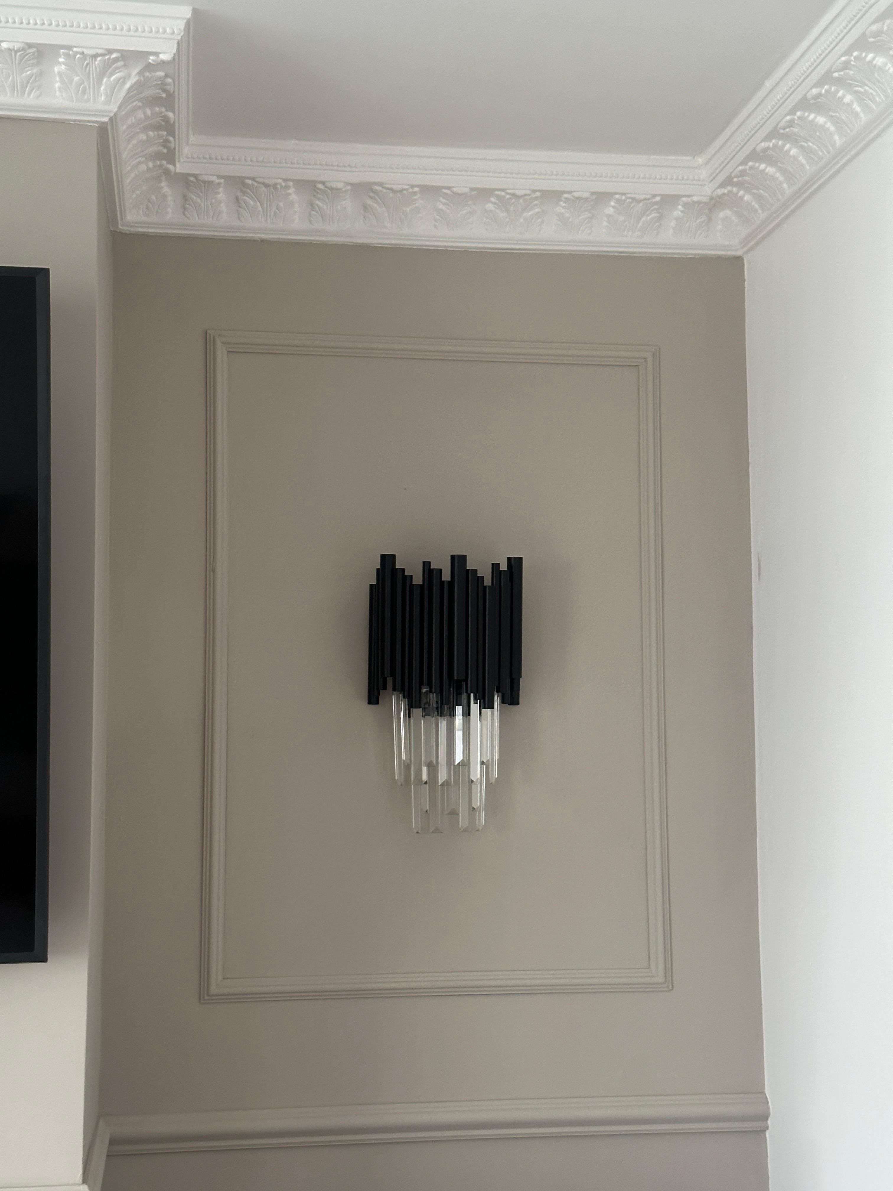 Gotham wall light mounted on a panelled wall showcasing crystal bar detailing