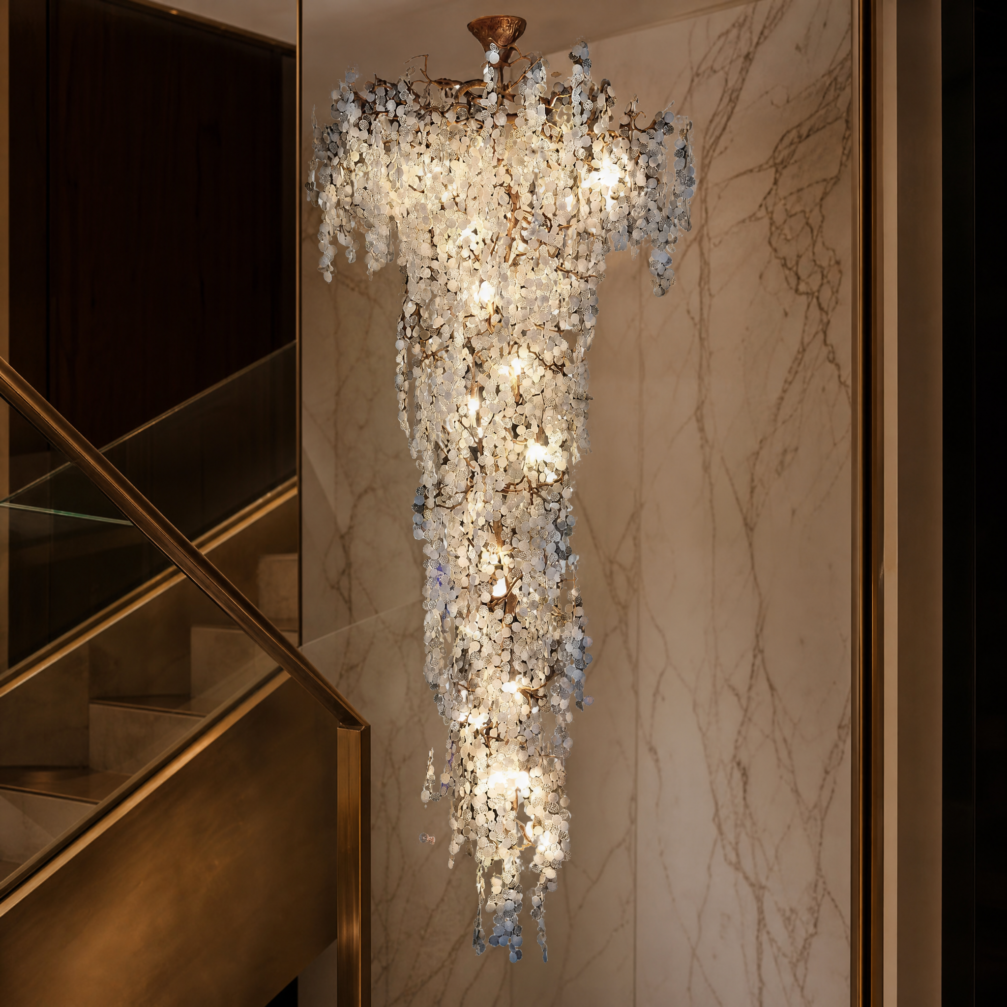 A detailed closeup of the VORELLI Lunaria Linear Chandelier, highlighting the intricate texture of the cascading glass discs and the fluid movement of the design.