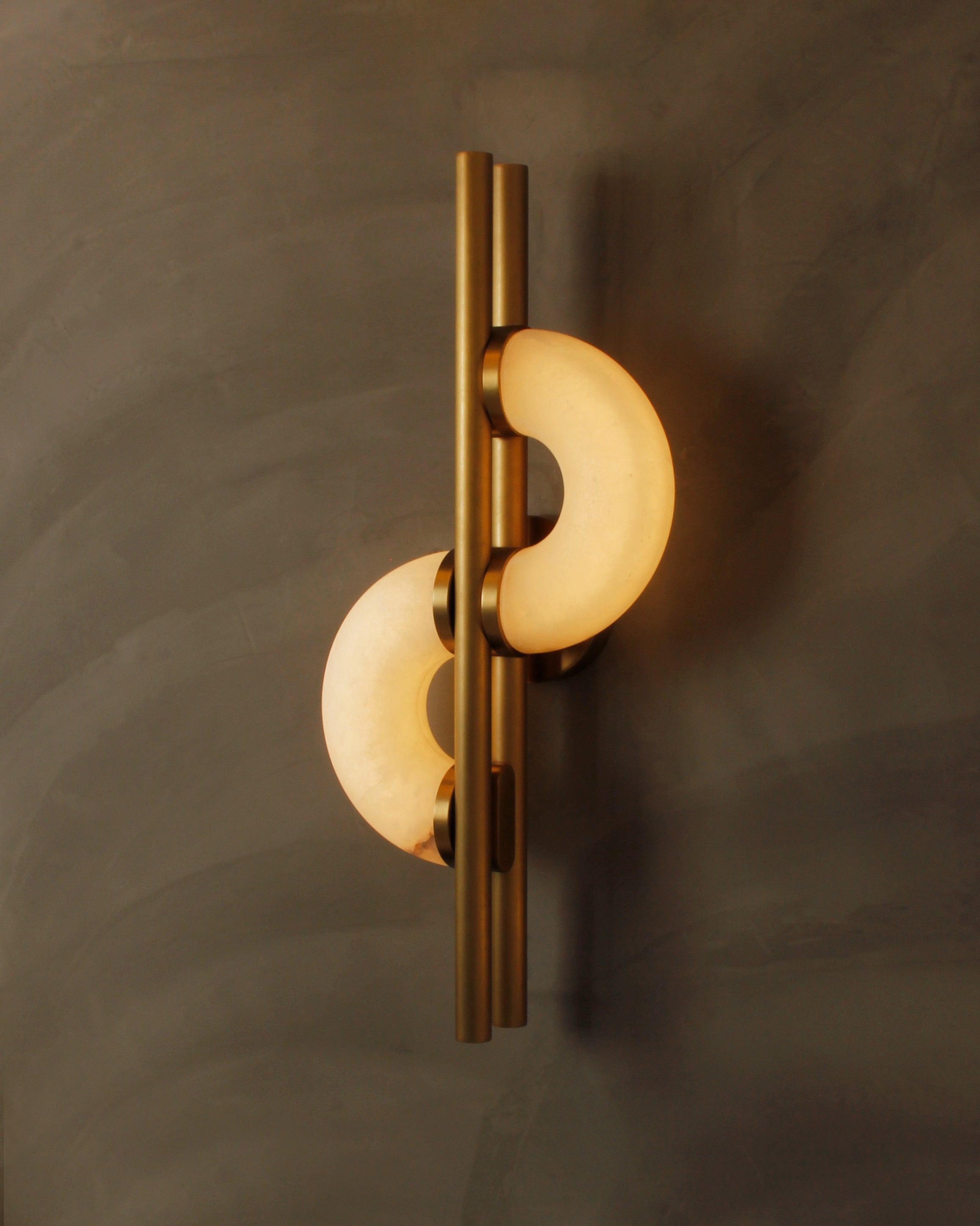Angled detail of Lunaro marble wall light highlighting brass frame and curved marble forms