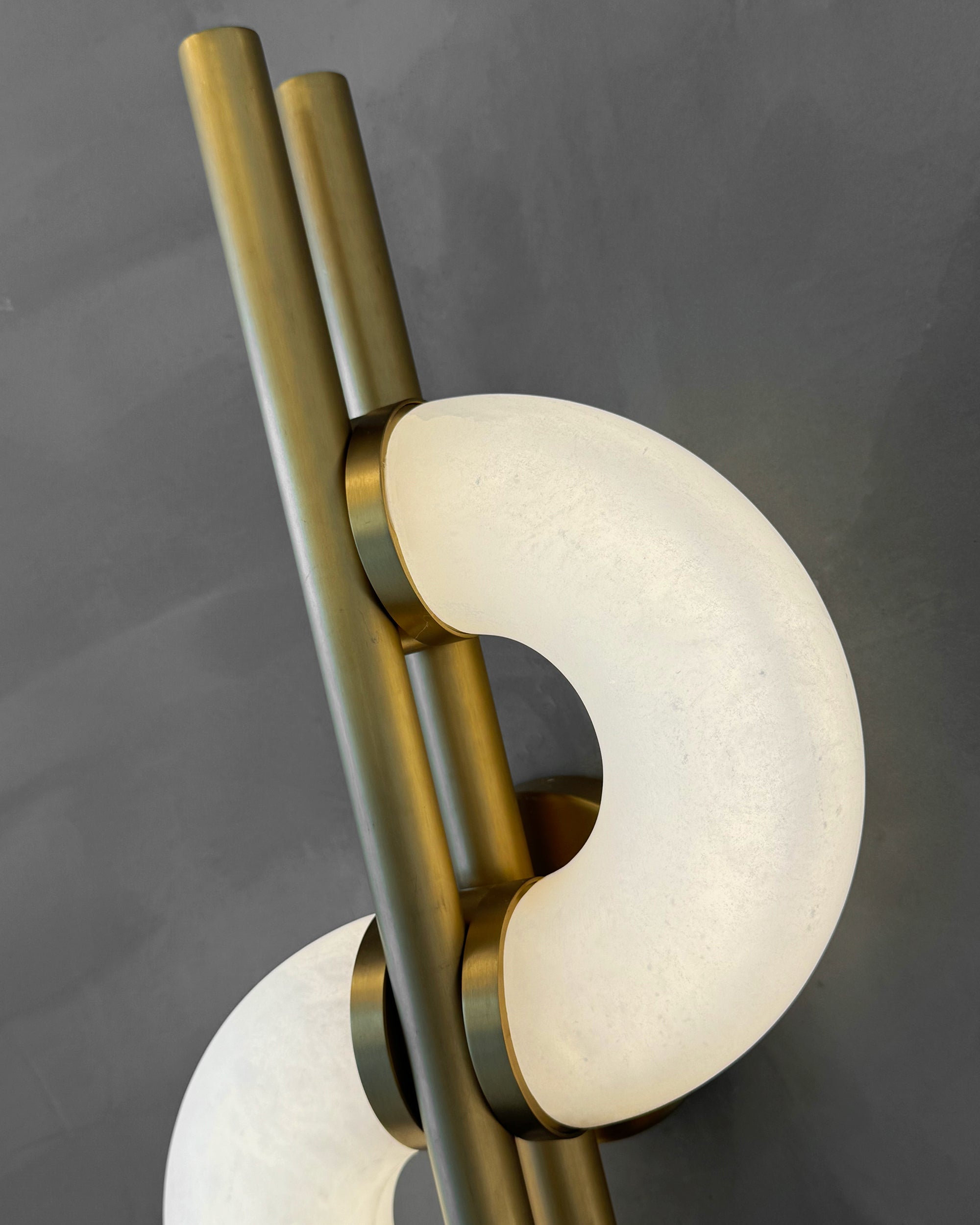 Close-up of Lunaro marble wall light showing crescent marble detail and brushed brass frame