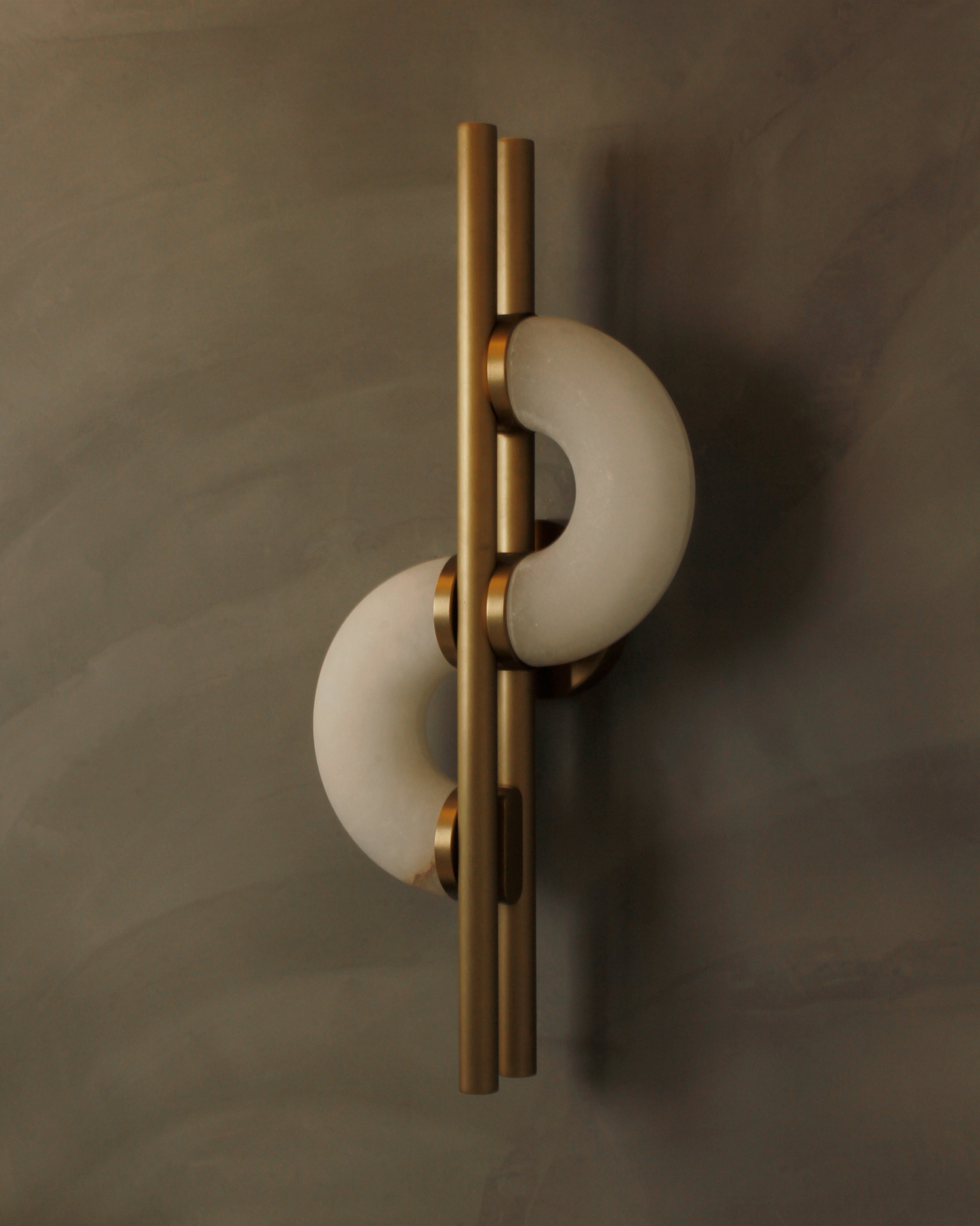 Side close-up of Lunaro marble wall light showing layered crescent marble and brass finish