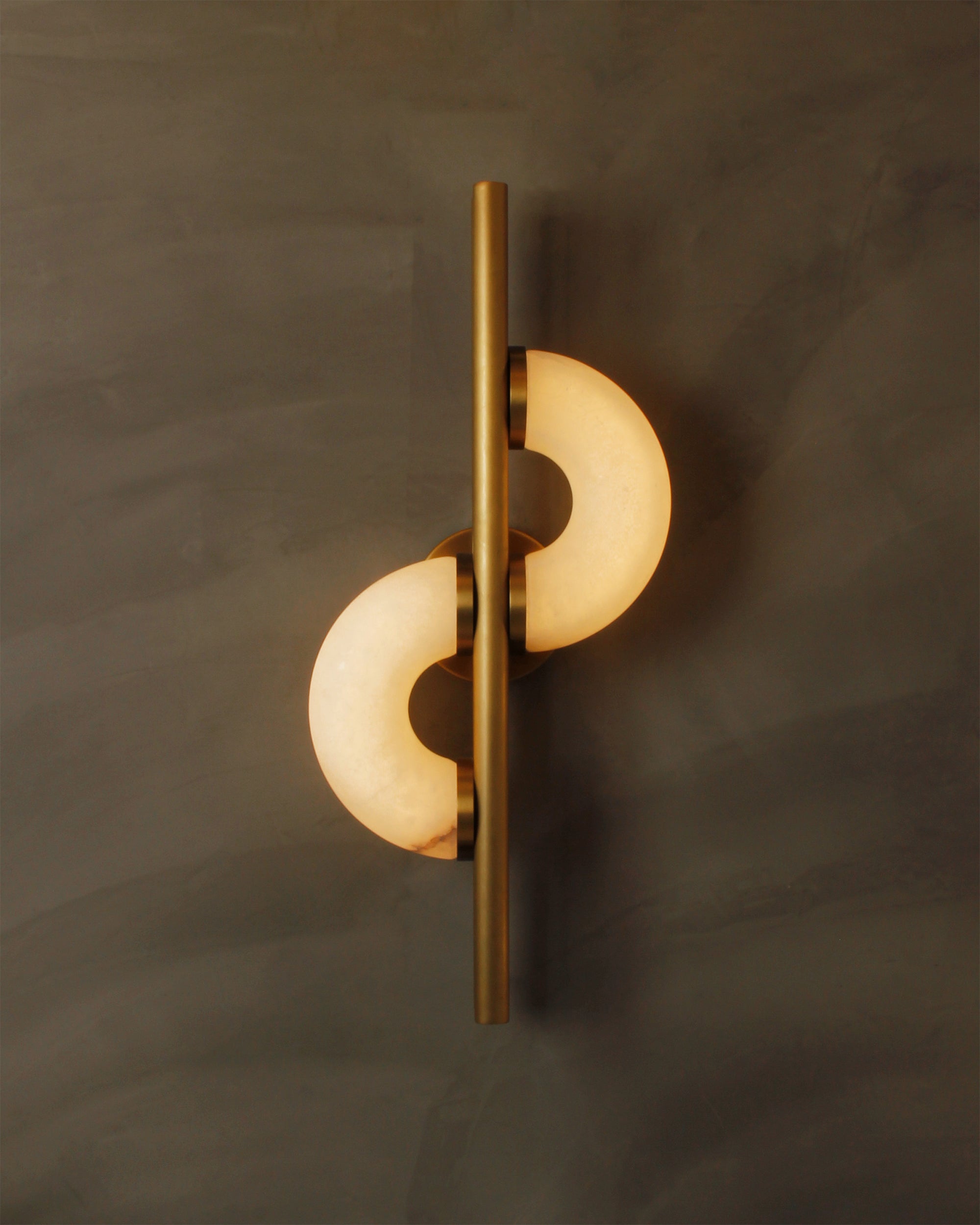 Close view of Lunaro marble wall light emitting soft warm illumination from crescent marble