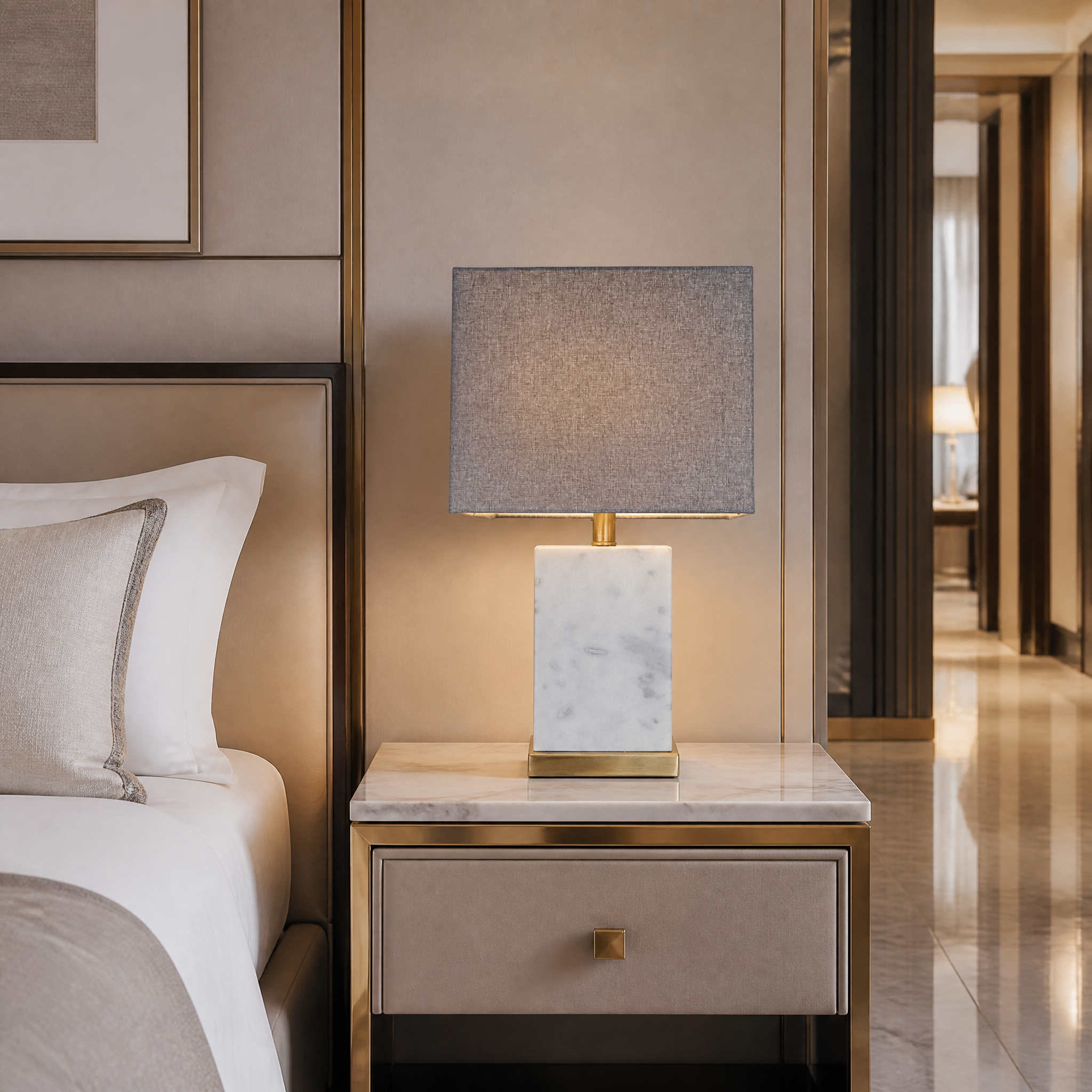 The Marvella marble and brass table lamp styled on a hotel bedside table to provide soft ambient lighting.
