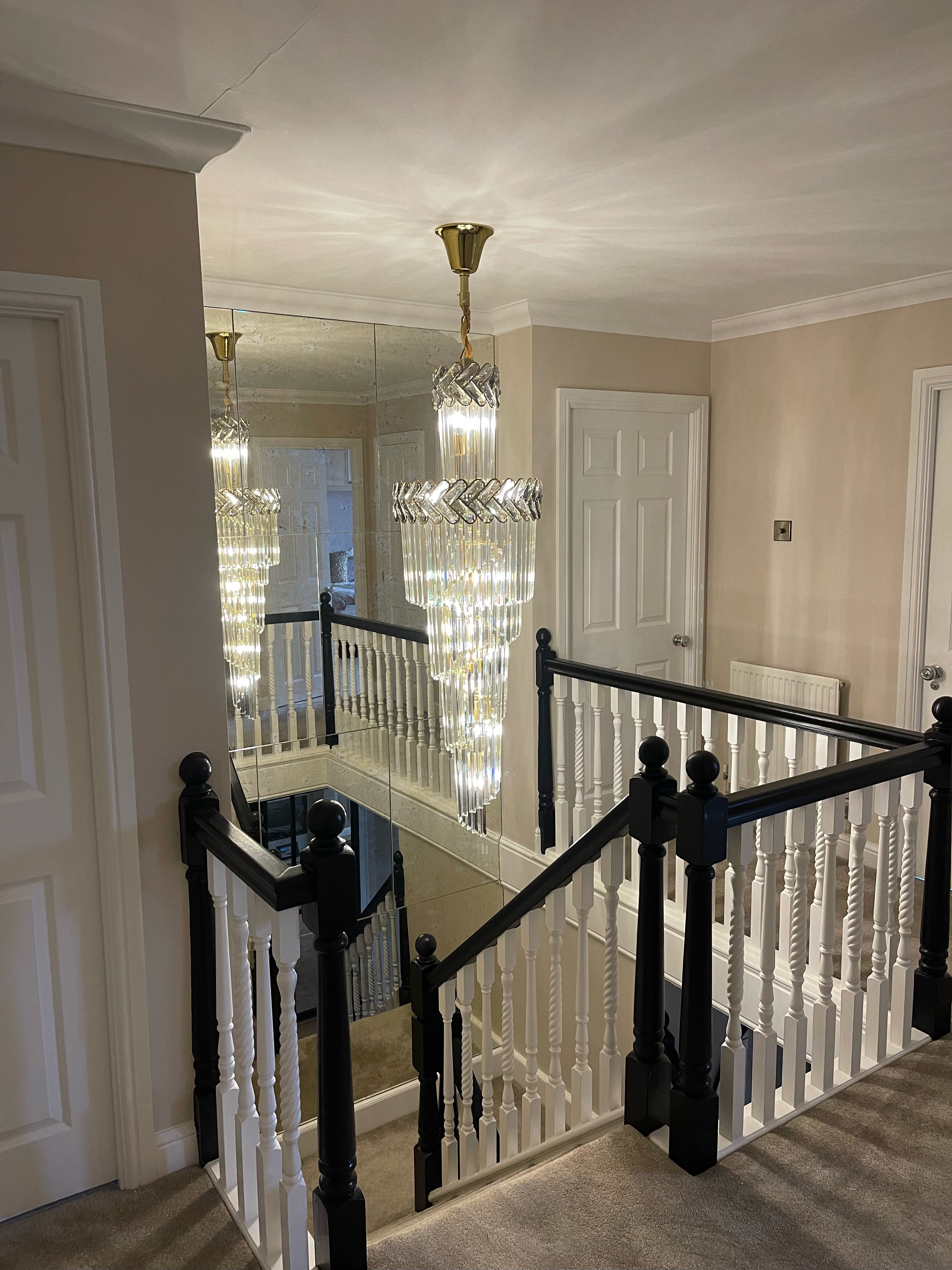 Luxury spiral staircase chandelier by VORELLI® illuminating a contemporary interior stairwell