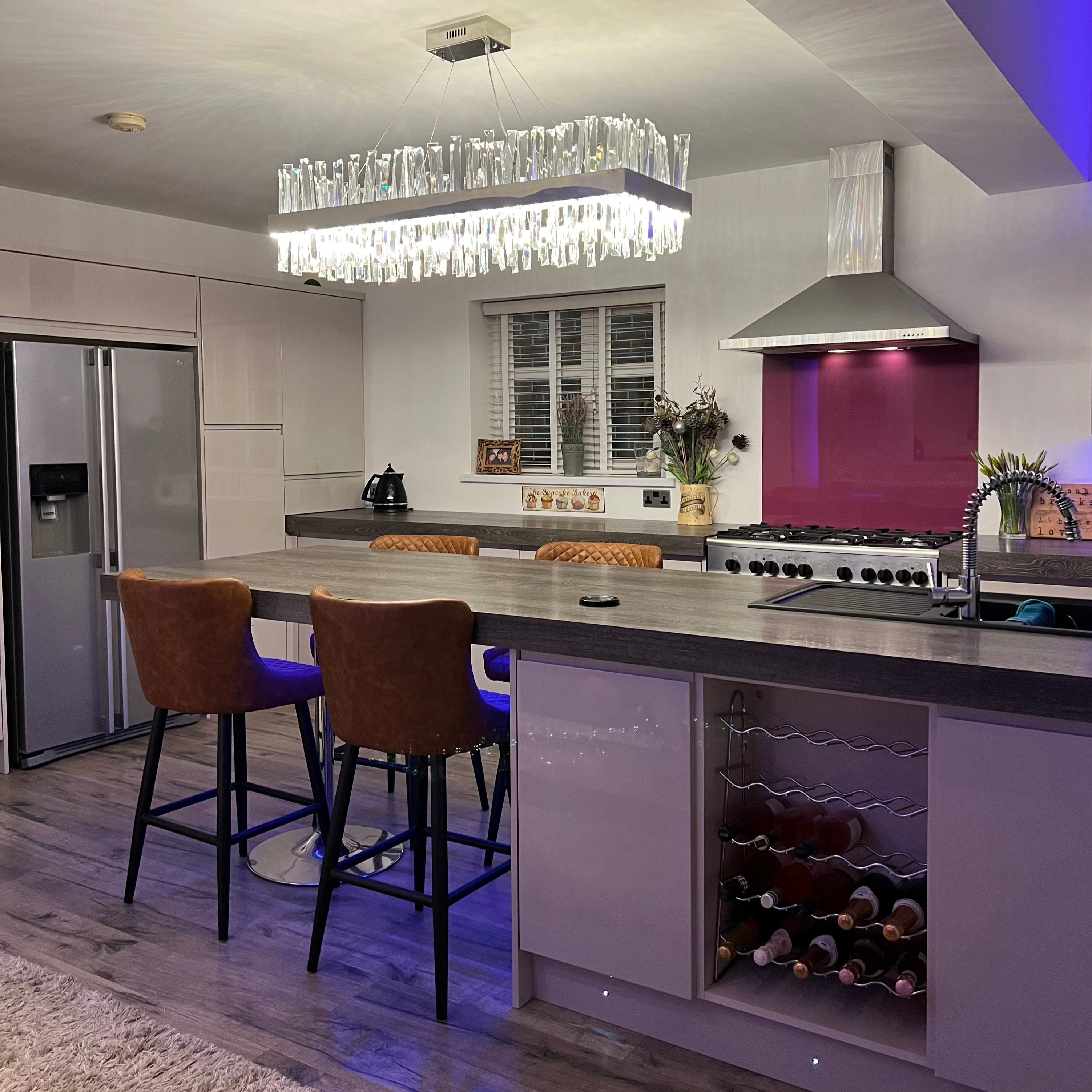 Luxury rectangular crystal bar chandelier viewed across a modern kitchen seating area