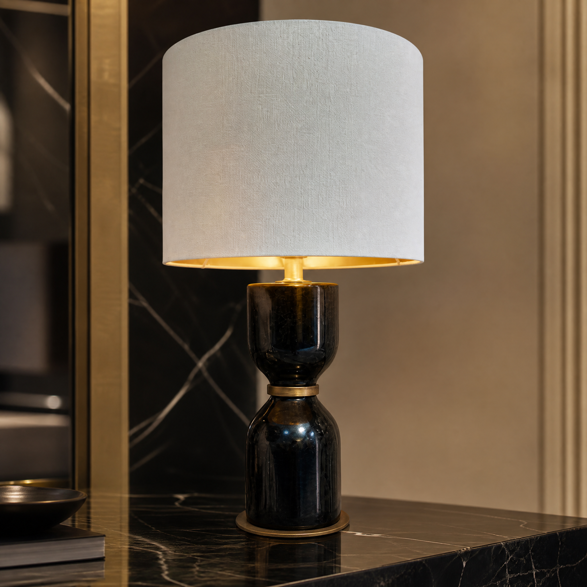 Close up detail of the sculpted black marble base and warm bronze detailing on the Noiré table lamp