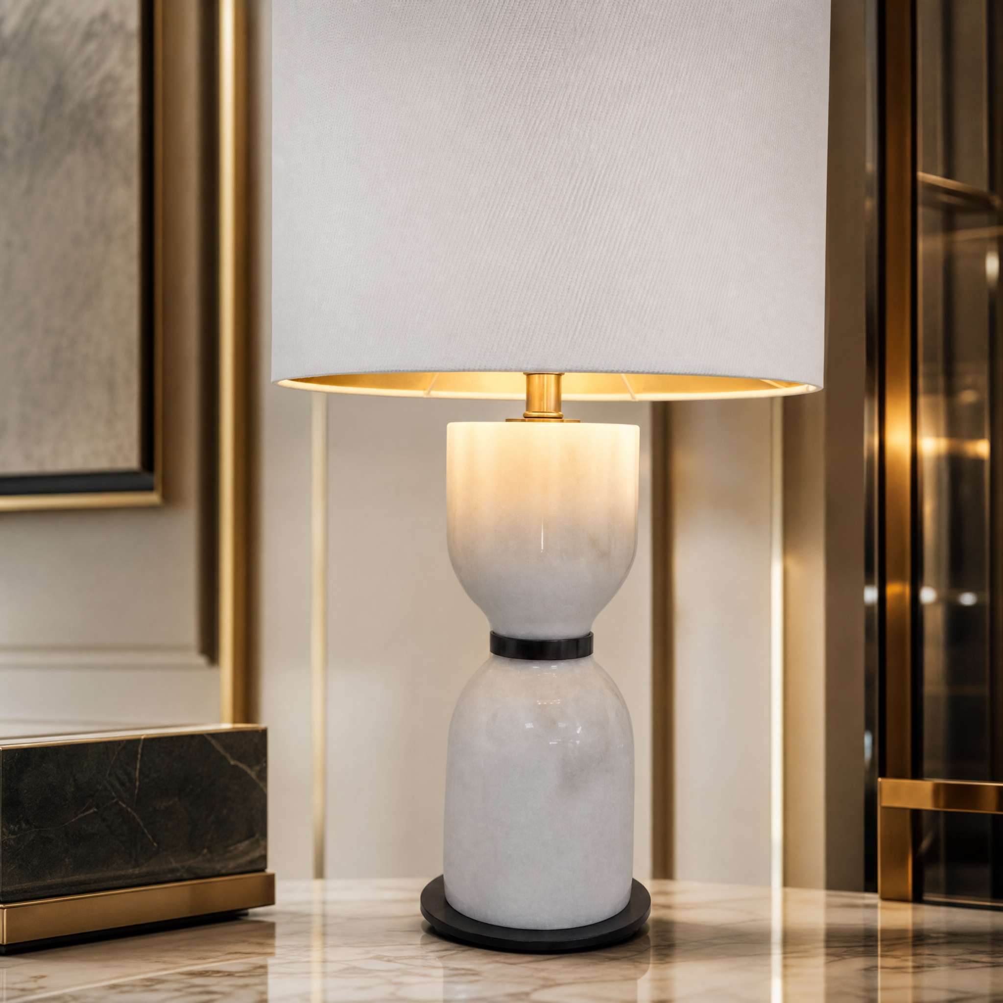 Close-up shot of the VORELLI Noiré table lamp, highlighting the texture of the sculpted white marble base and refined bronze detailing.