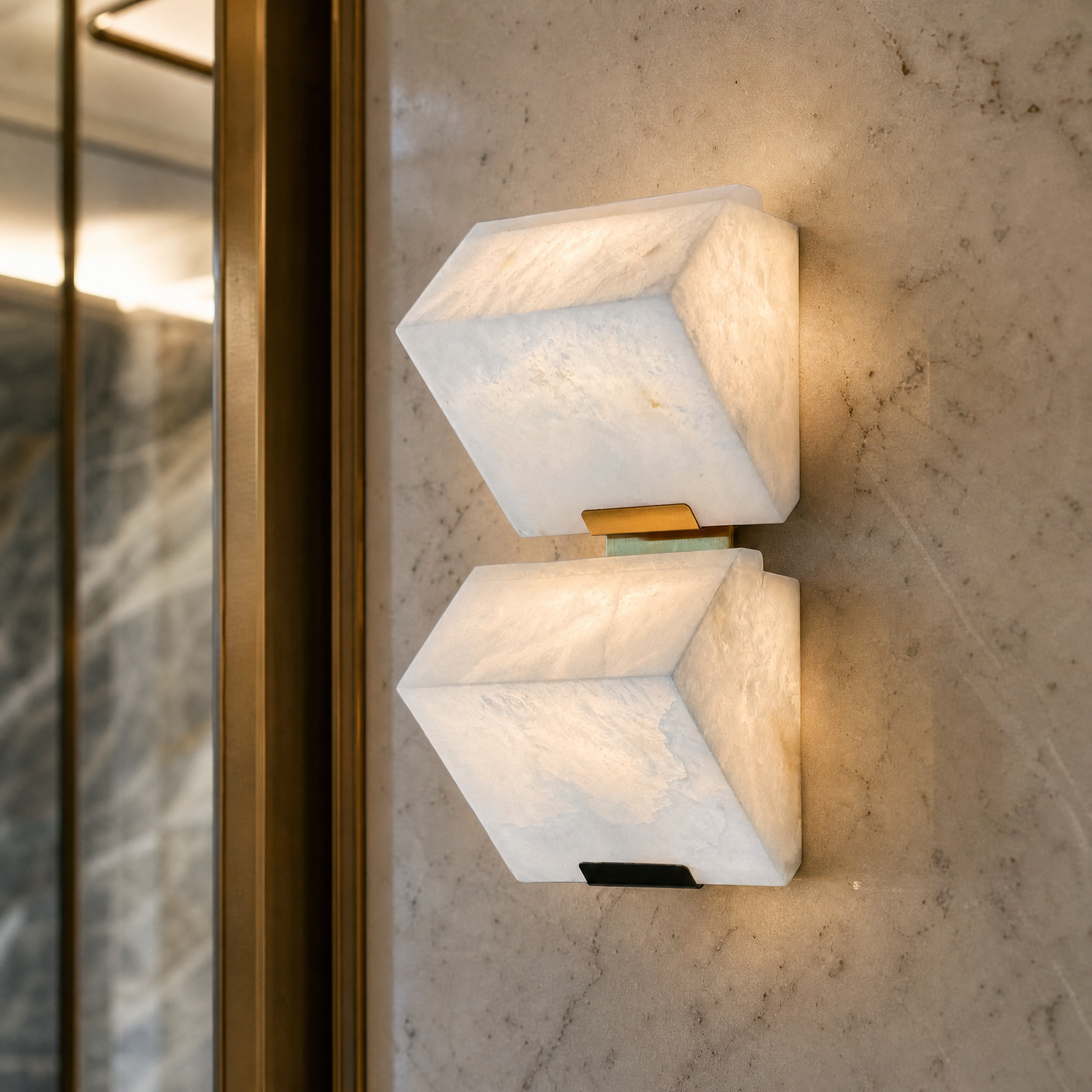 Macro closeup of the glowing dual-block marble surface of the Novara modern wall light, detailing its natural stone textures.