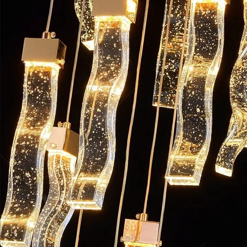 Close-up of glowing crystal pendants on the VORELLI® Palazzo staircase chandelier showing warm LED sparkle and refined luxury detail