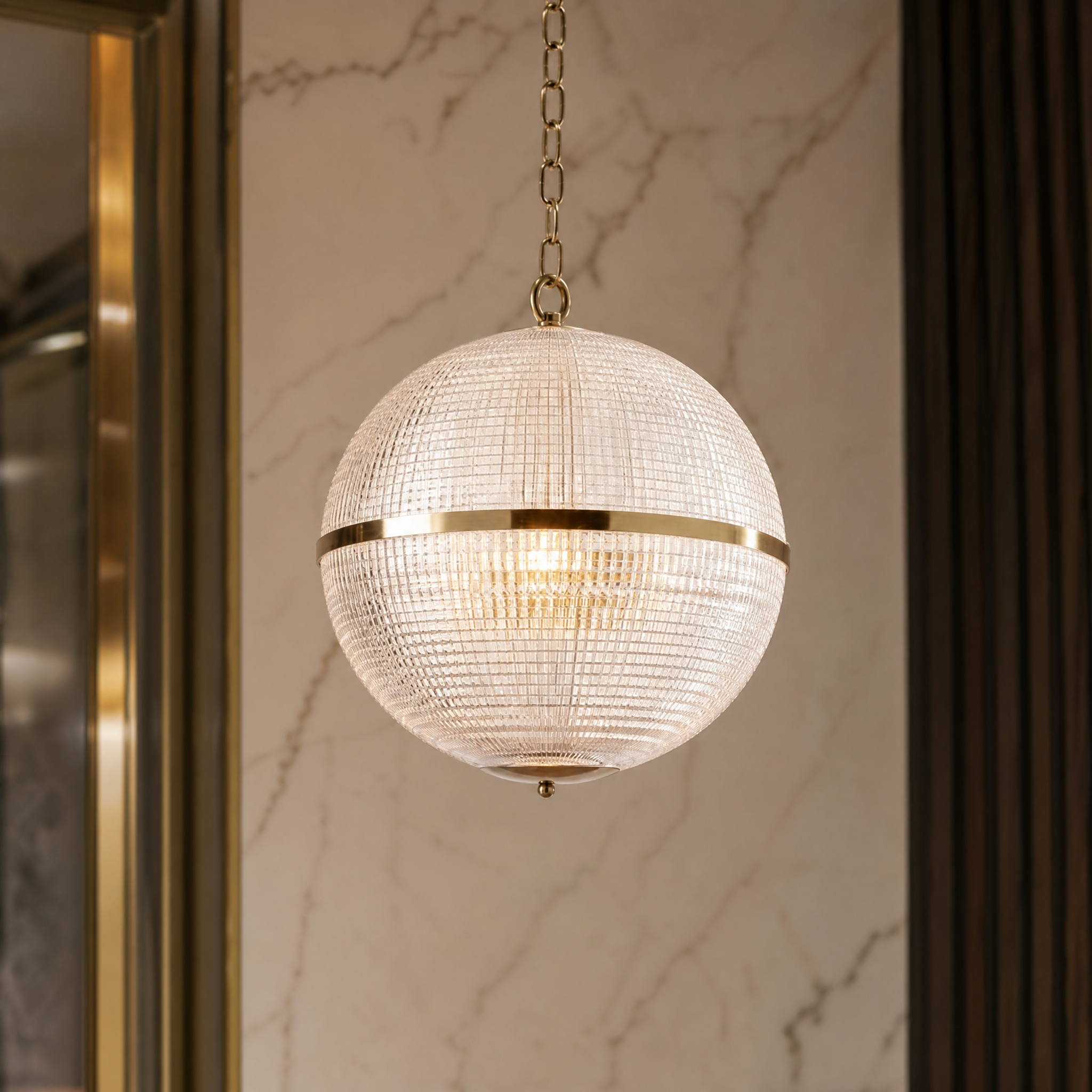 Close-up detail of the Parigino IP44 pendant showing the prismatic moulded glass globe and refined brass mounting hardware.
