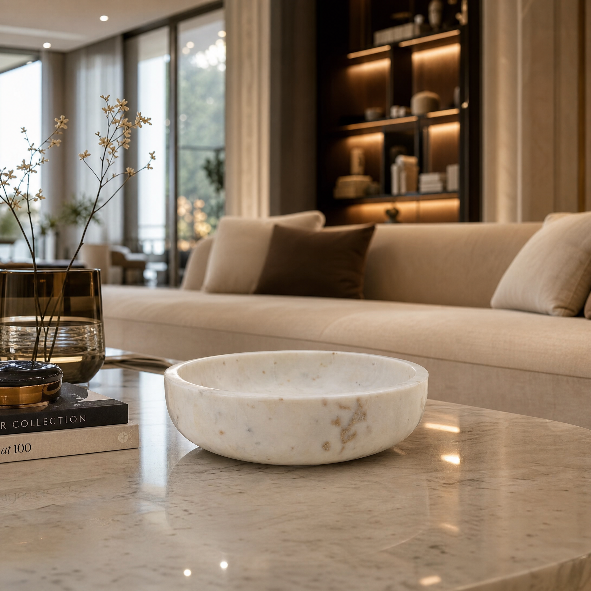 VORELLI Pietrina polished white marble bowl styled as an elegant living room centerpiece on a contemporary coffee table.