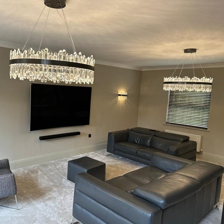 Sagres circular crystal chandelier suspended in upscale lounge interior with dual tone frame design