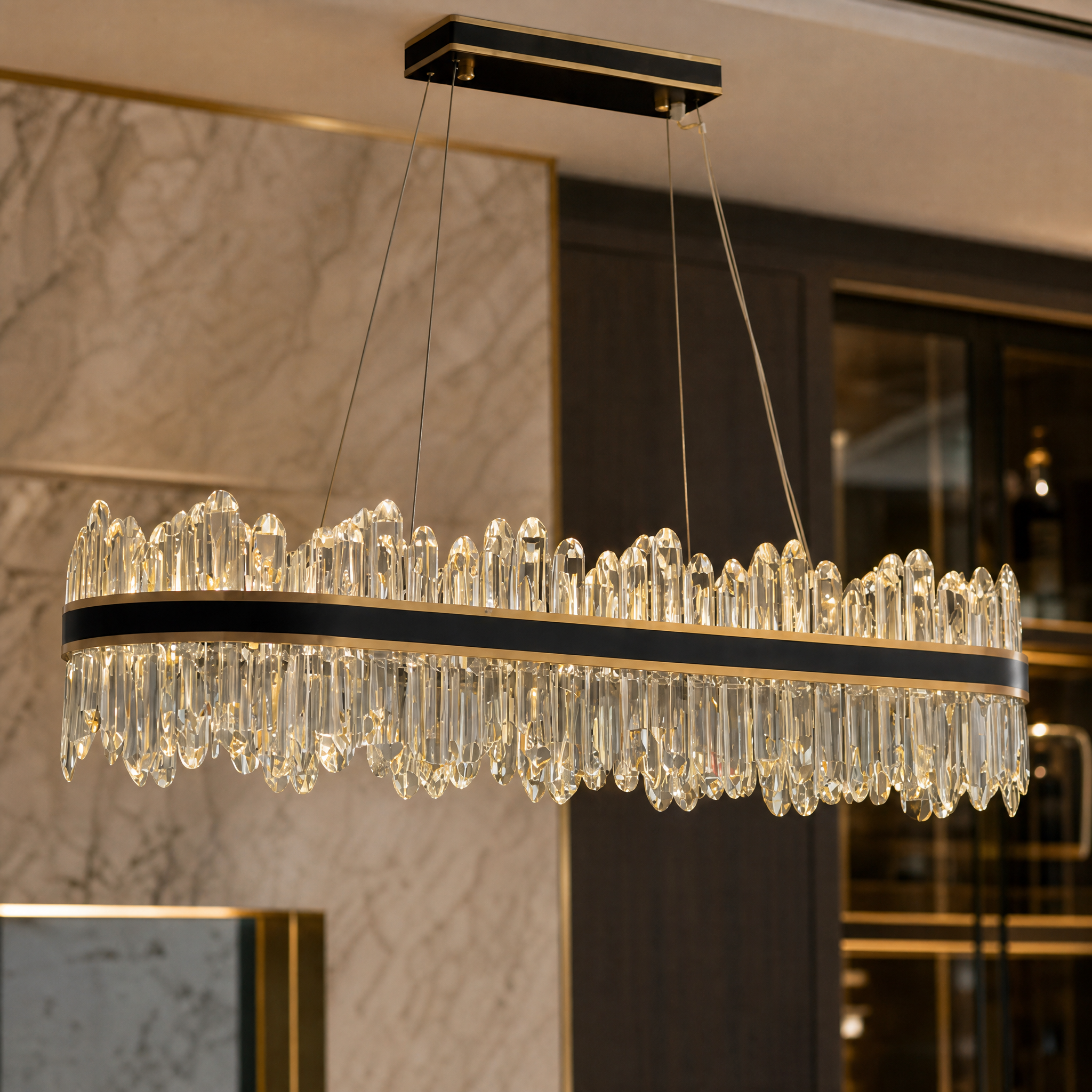 Macro shot of the diamond cut oblong crystals and brushed titanium gold trim on the Sagres Rectangular Chandelier.