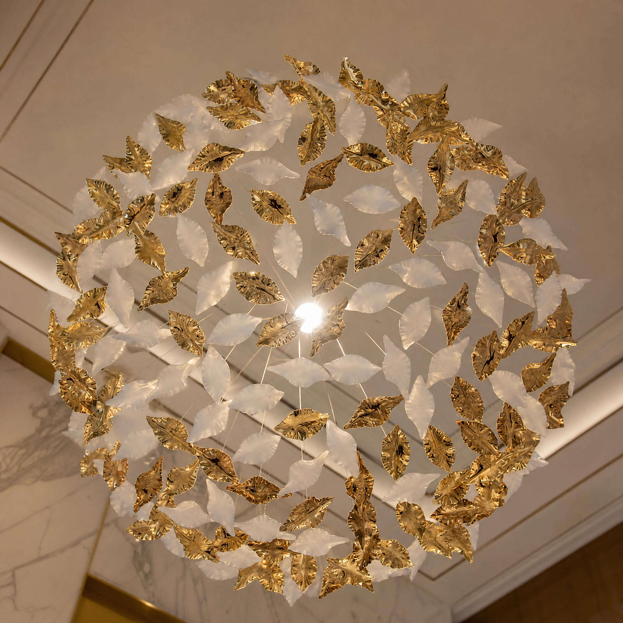 Close-up detail of delicately sculpted glass leaves from the VORELLI installation, capturing the elegant layered composition and texture.