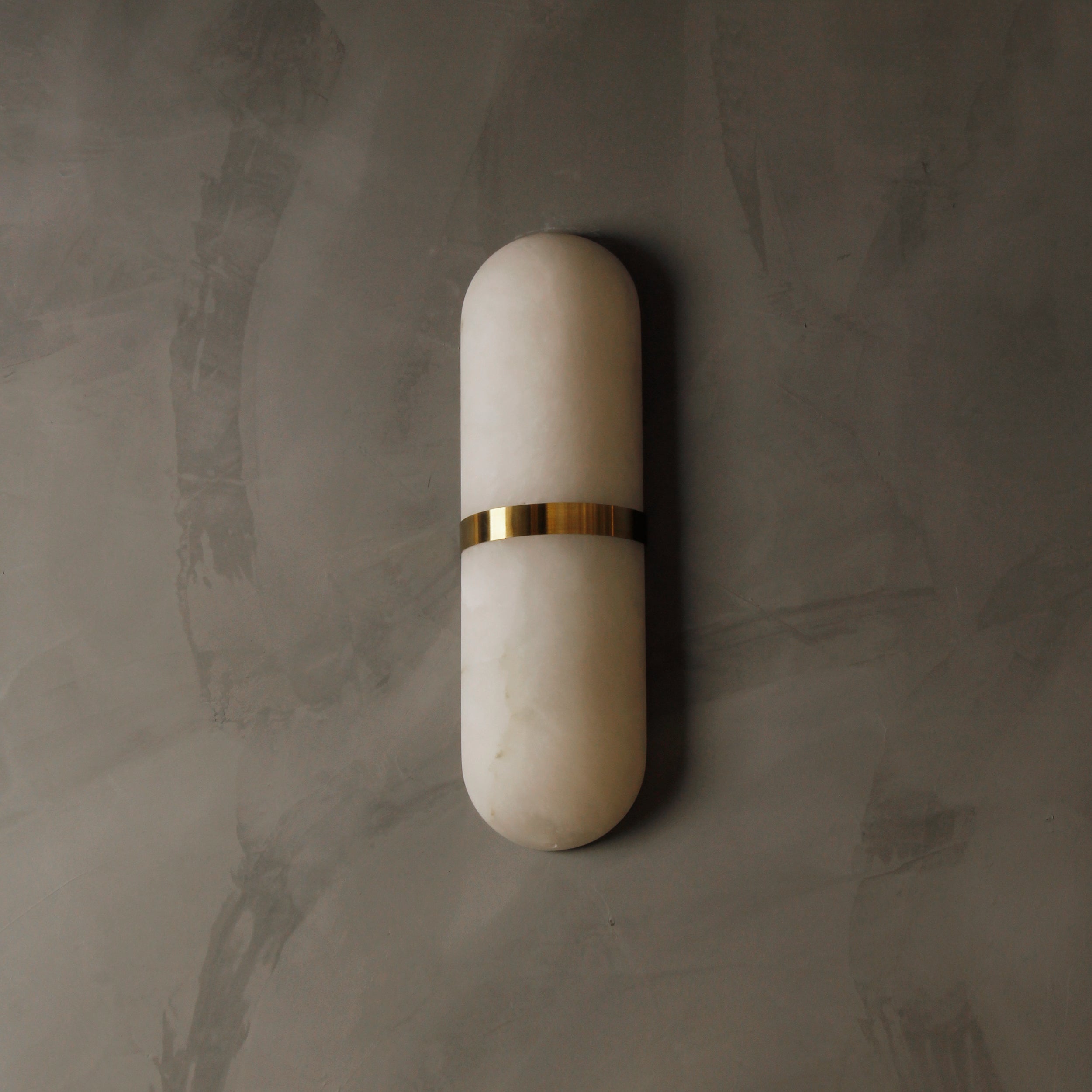 Serene minimalist marble wall lamp showcasing smooth rounded stone silhouette and clean architectural lines