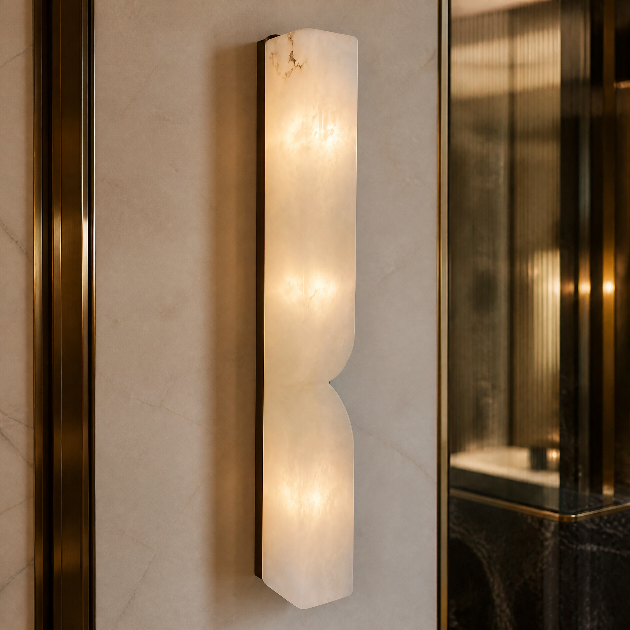 A macro close-up view of the sculpted natural marble and hourglass form of the Sienna Wall Light.