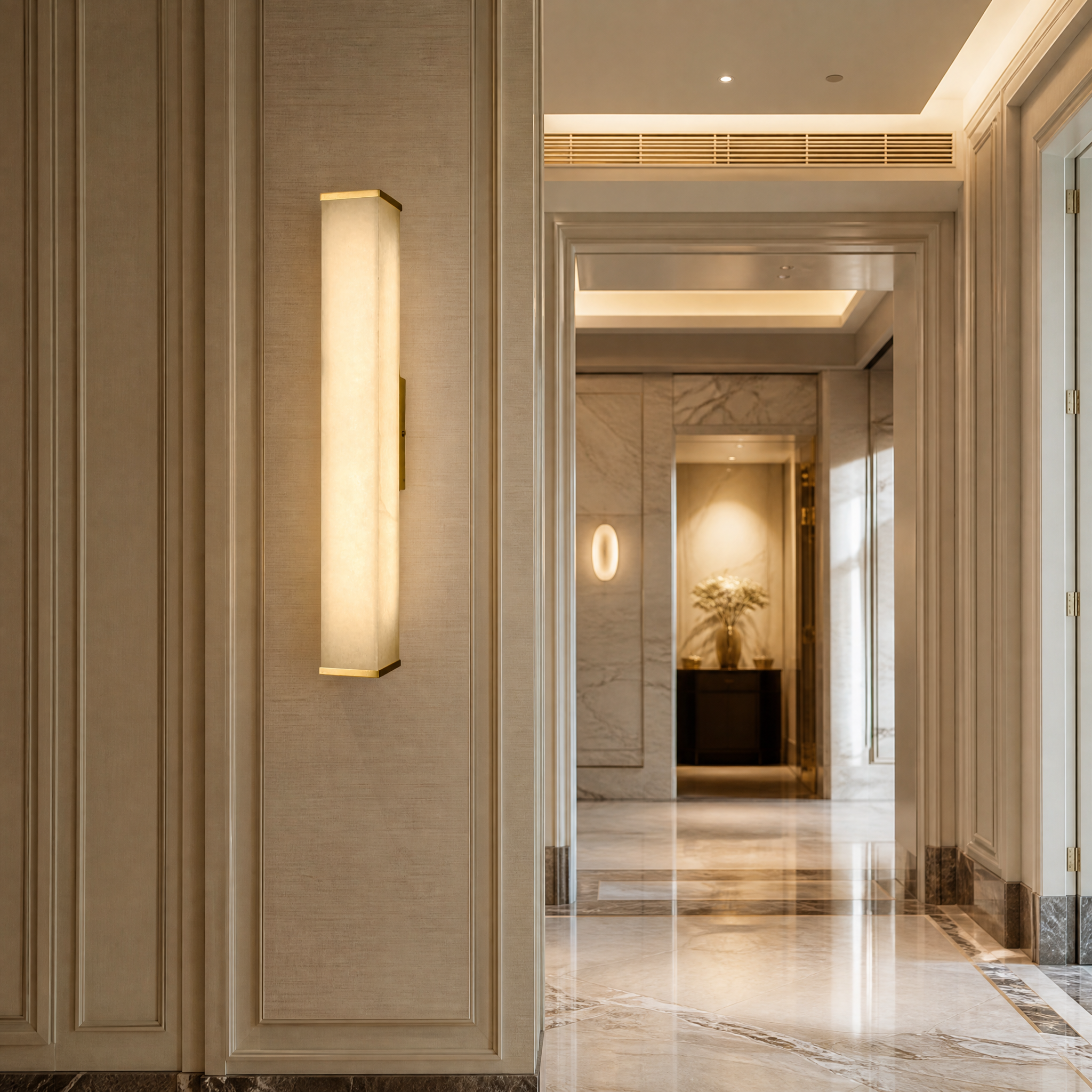 A pair of minimalist Socrates marble wall sconces by VORELLI illuminating a sophisticated boutique hotel lobby corridor with understated elegance.