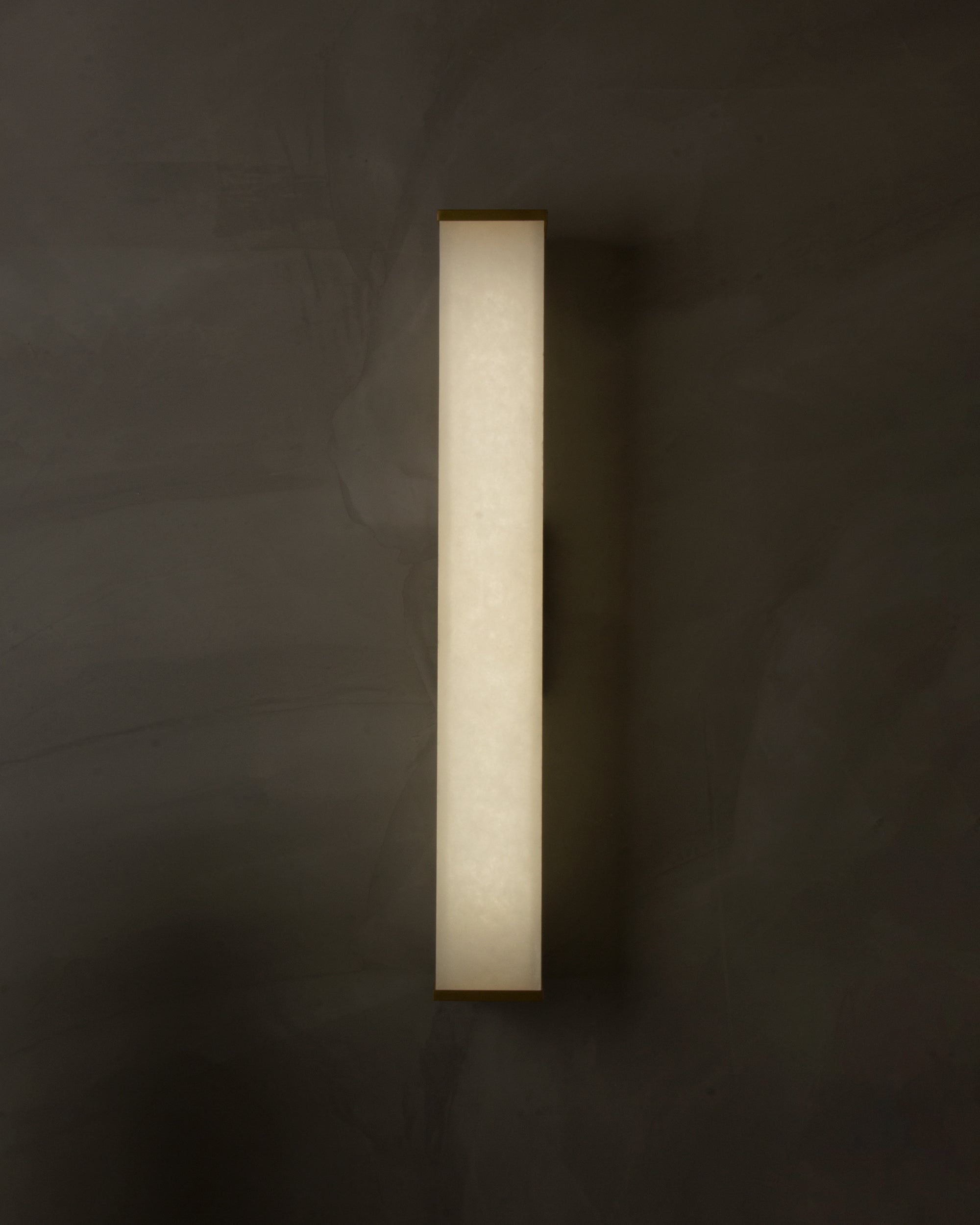 Socrates modern slim marble wall sconce installed in refined interior creating soft ambient glow