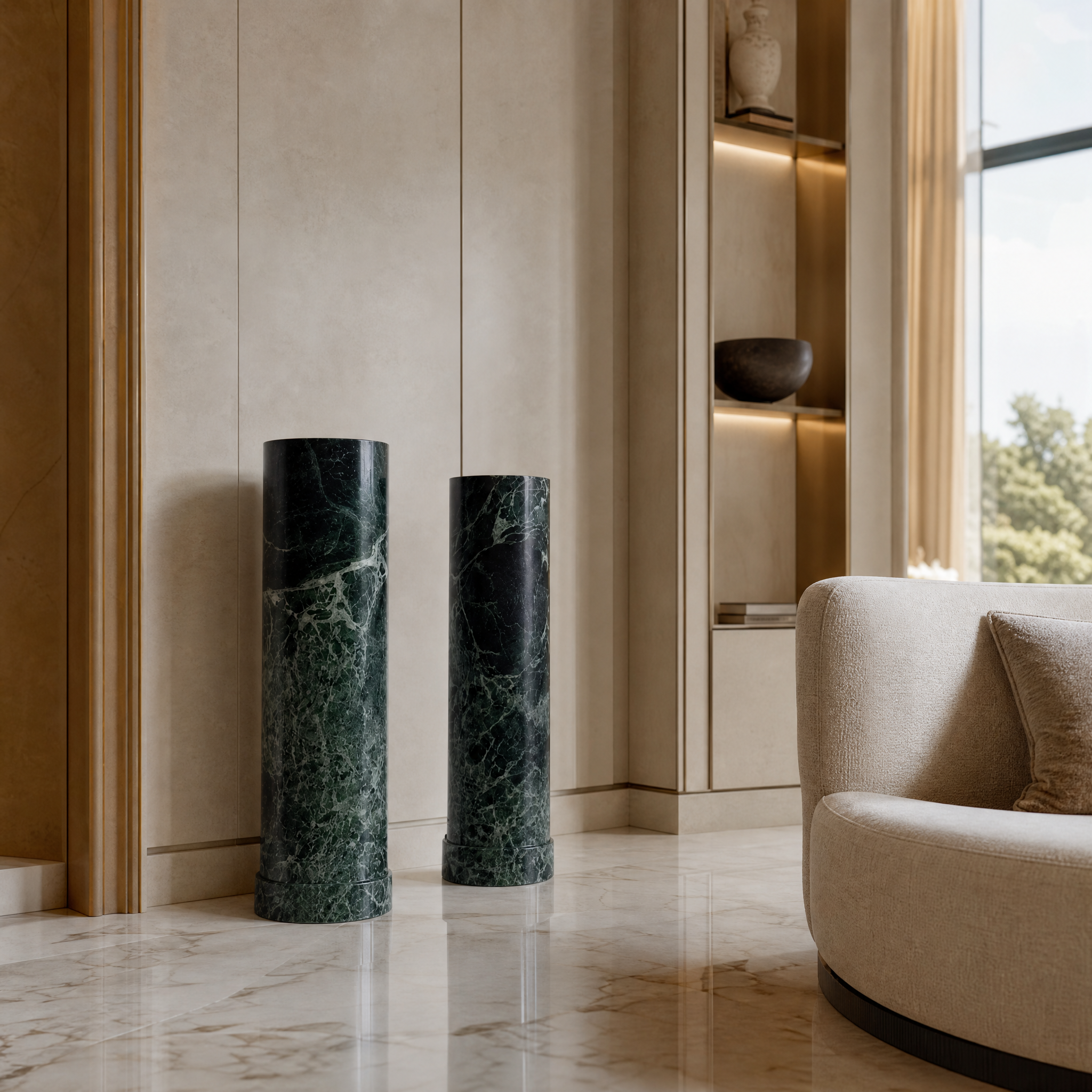 A luxurious Verano Prada Green marble column standing in a modern residential entryway featuring striking natural emerald veining.