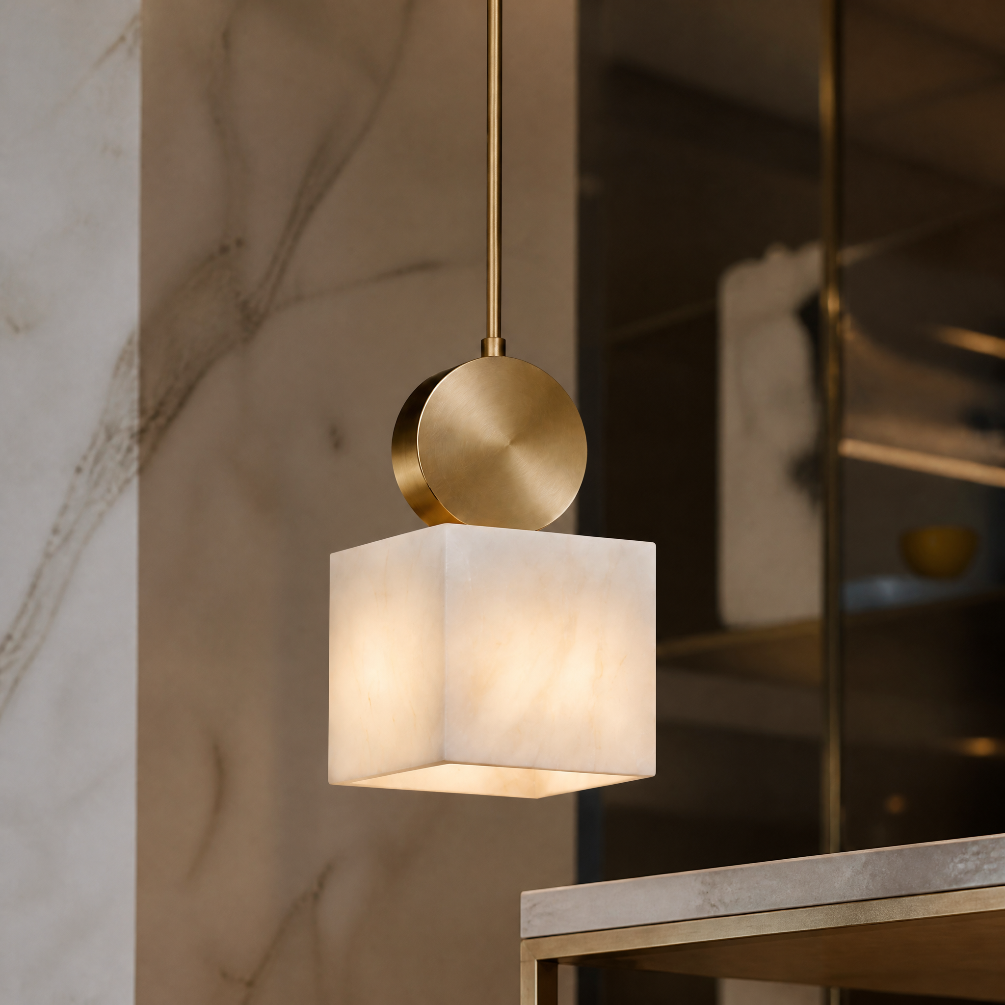 Macro shot of the VORELLI Hera pendant light highlighting the rich texture of the cube-shaped marble and the refined brushed gold accent metalwork.