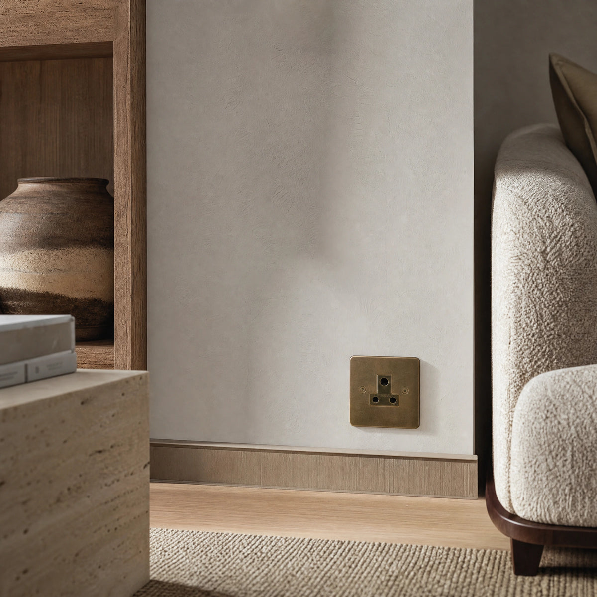 Luxury antique brass 5a socket installed within bespoke bedside joinery or low-level wall beside a luxury seating area in a UHNW interior by VORELLI®.