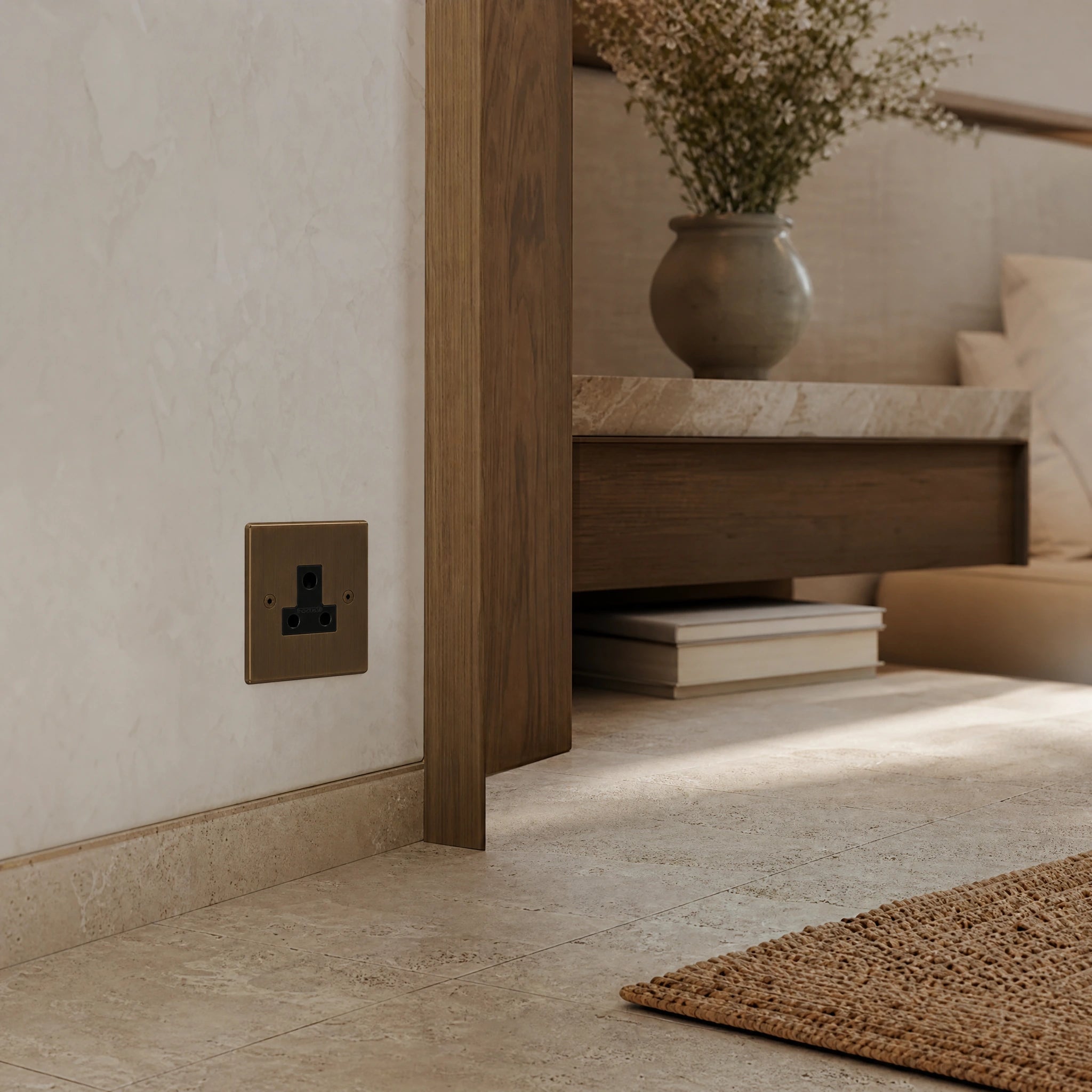 Luxury antique bronze 5a socket installed within bespoke bedside joinery or low-level wall beside a luxury seating area in a UHNW interior by VORELLI®.