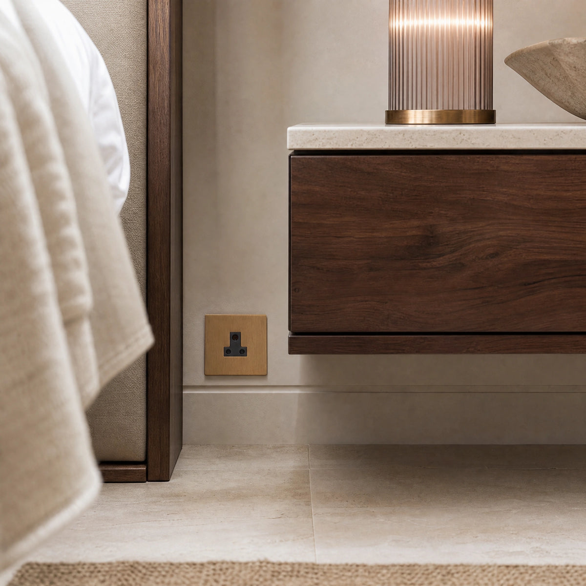 Luxury sienna 5a socket installed within bespoke bedside joinery or low-level wall beside a luxury seating area in a UHNW interior by VORELLI®.