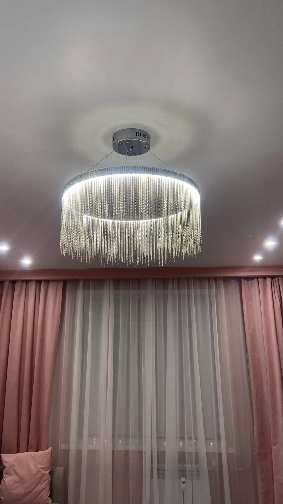 Luxury Adlington circular chandelier by VORELLI® featuring cascading crystal chains, styled in an elegant bedroom interior
