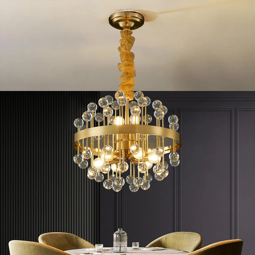 Alytus circular chandelier with clear crystals and gold frame suspended above a luxury dining table.