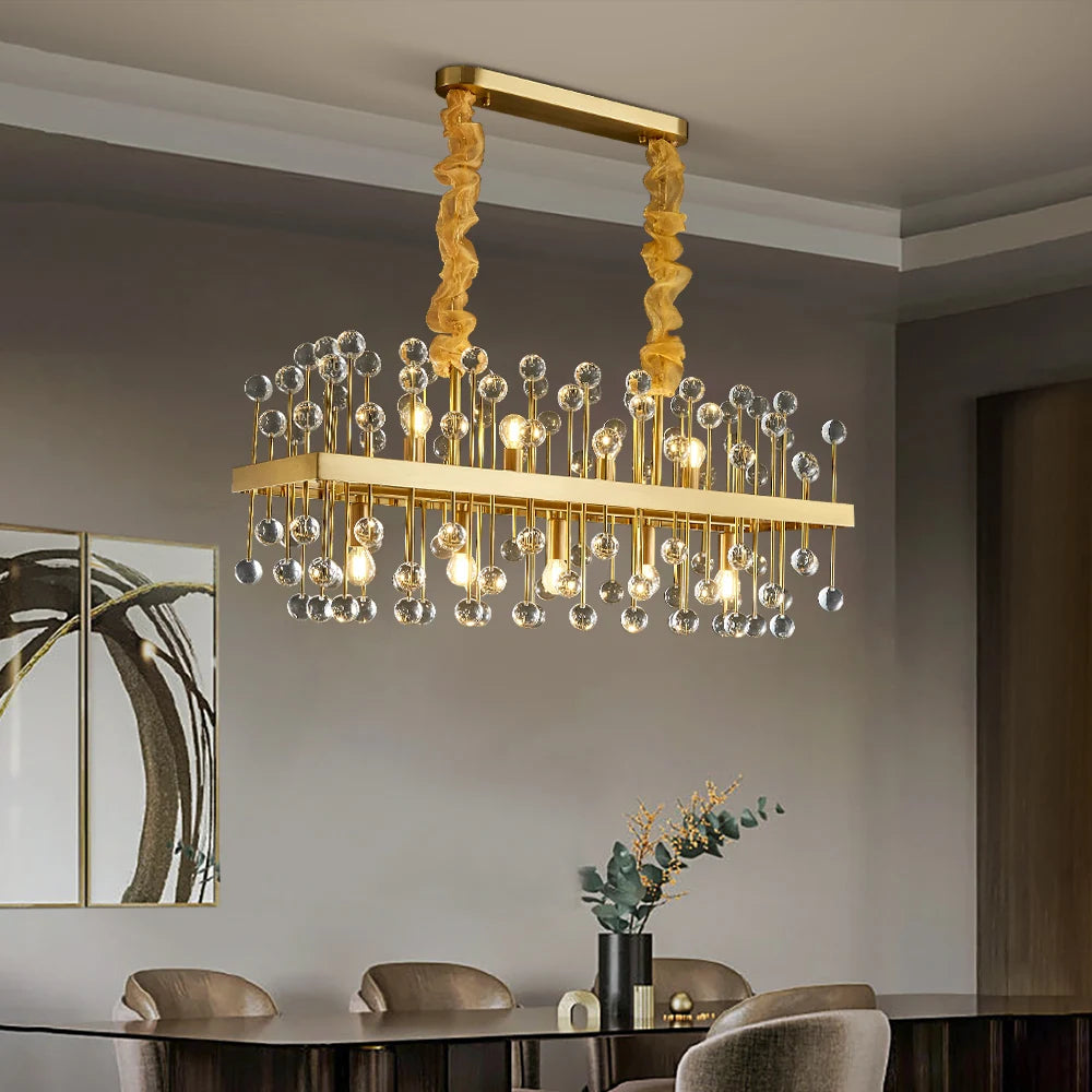Clear crystal Alytus Rectangular Chandelier with a brushed gold frame in a minimalist dining space.