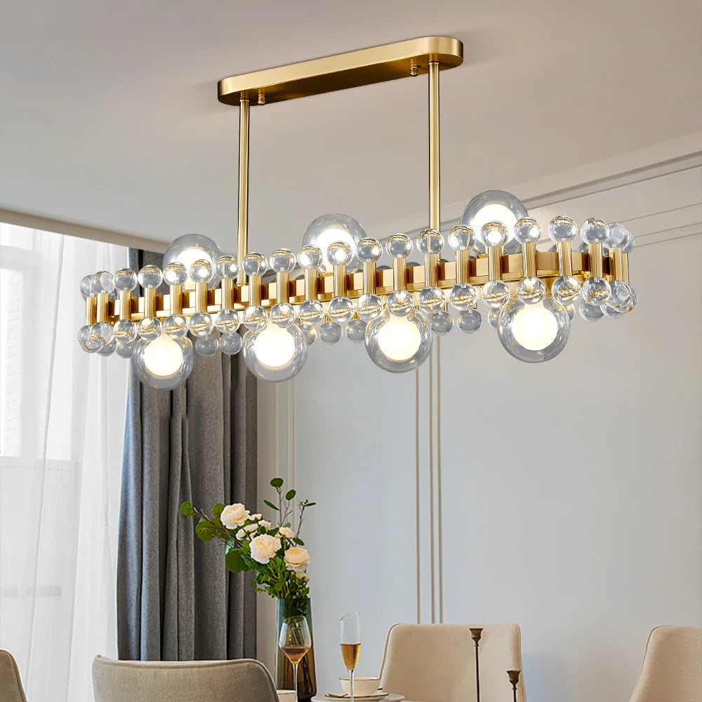 Side perspective of Alytus Rectangular Chandelier II with refined clear crystals and gold bar detailing.