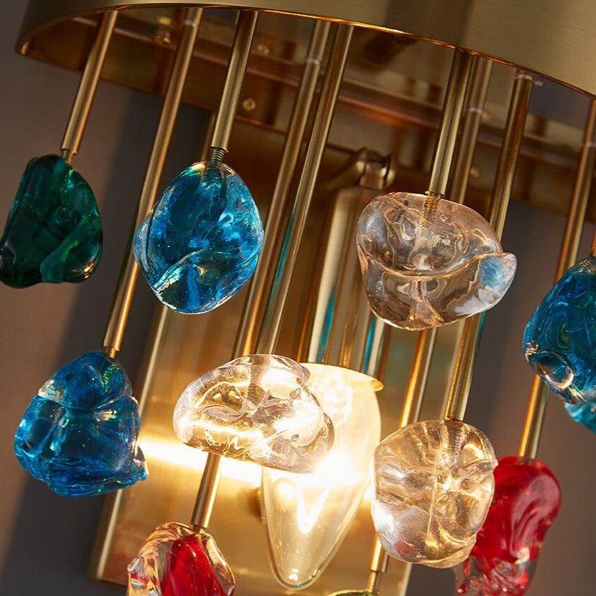 Close-up of the Alytus Wall Light showcasing vibrant red, green, and blue glass crystals suspended from gold arms.