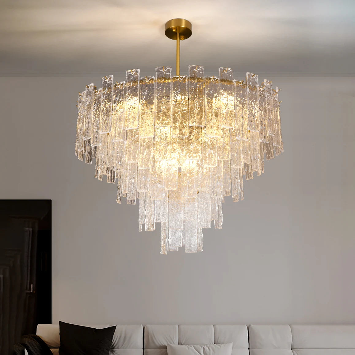 Ambani Circular Chandelier featuring cascading cracked crystal elements, suspended above a contemporary sofa in a modern living room.