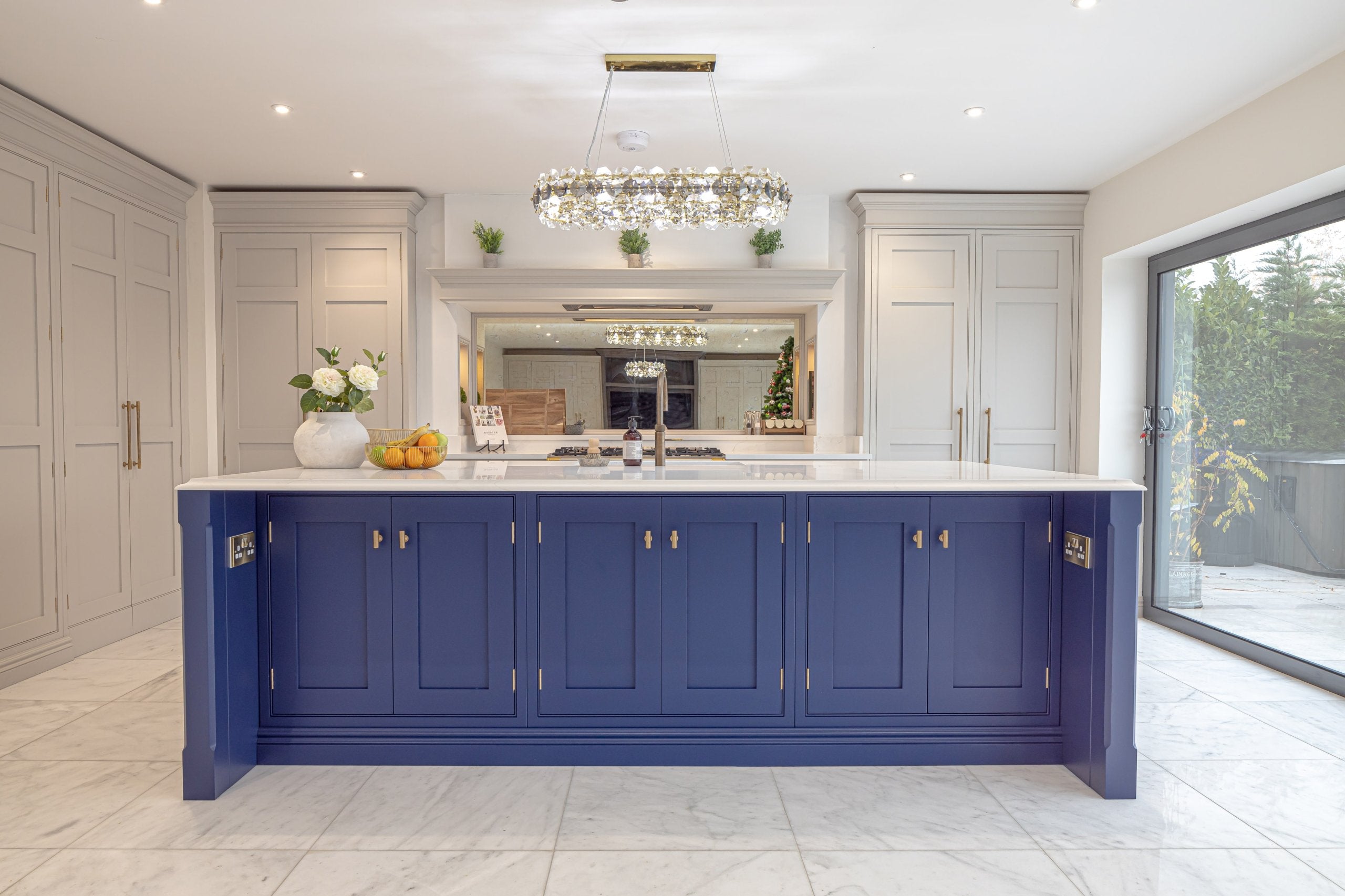 Luxury open-plan kitchen featuring the Astoria rectangular chandelier with diamond cut crystals above a bespoke kitchen island
