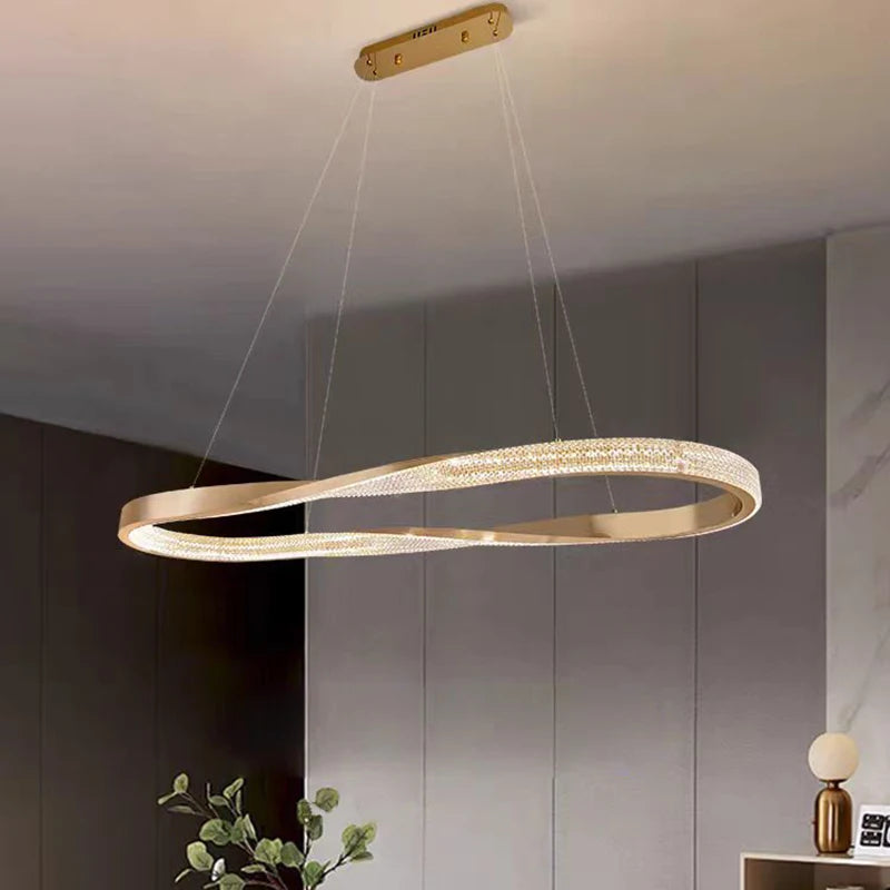 Sculptural rectangular chandelier with a twisted golden form in a modern interior.