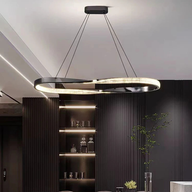 Twisted rectangular chandelier suspended above a contemporary staircase area.