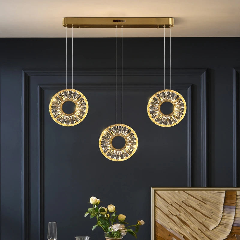 Rectangular Bocelli chandelier with illuminated crystal rings suspended in a modern interior.