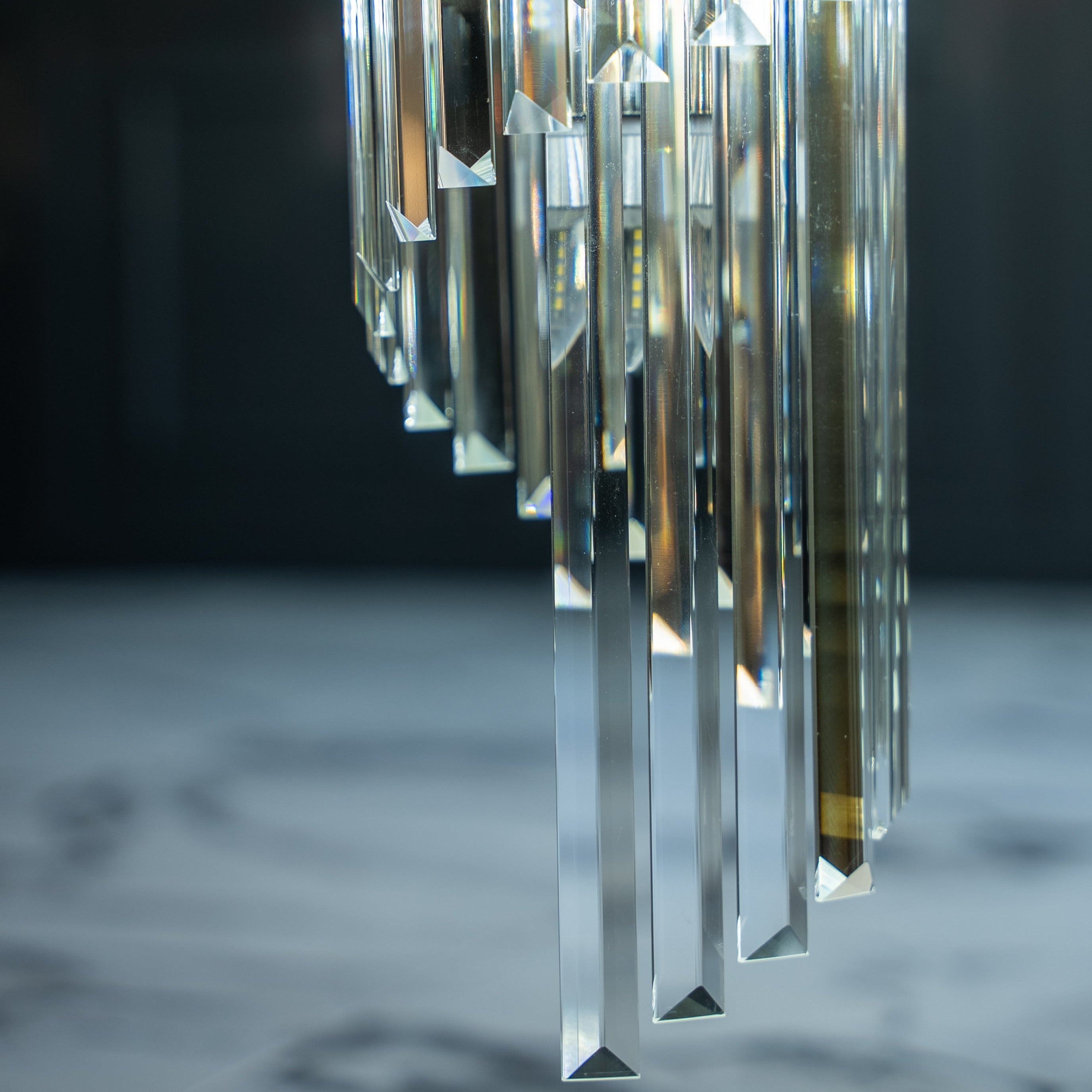 Close-up of the Boeotia Spiral Staircase Chandelier showing detailed gold cuboid tubing paired with faceted crystal bars.