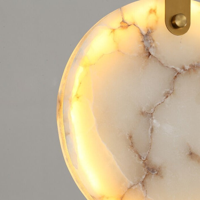Backlit circular Calacatta marble pendant highlighting refined craftsmanship and texture.