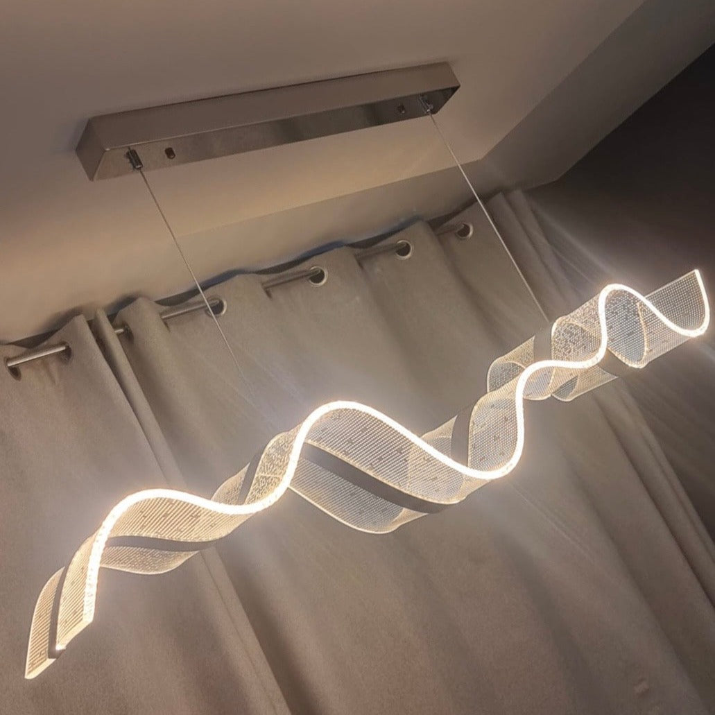 Close perspective of the Capitano chandelier’s illuminated curving light form, highlighting its sleek modern aesthetic