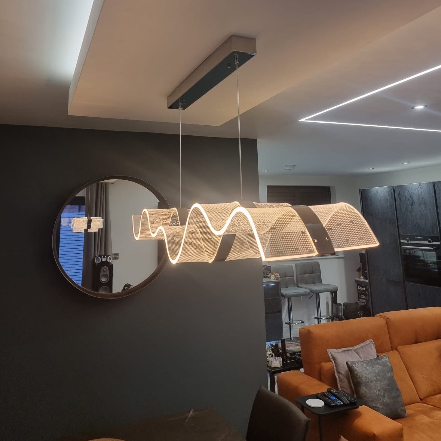 Side view of the Capitano Rectangular Chandelier showcasing its contemporary wave-shaped LED design.