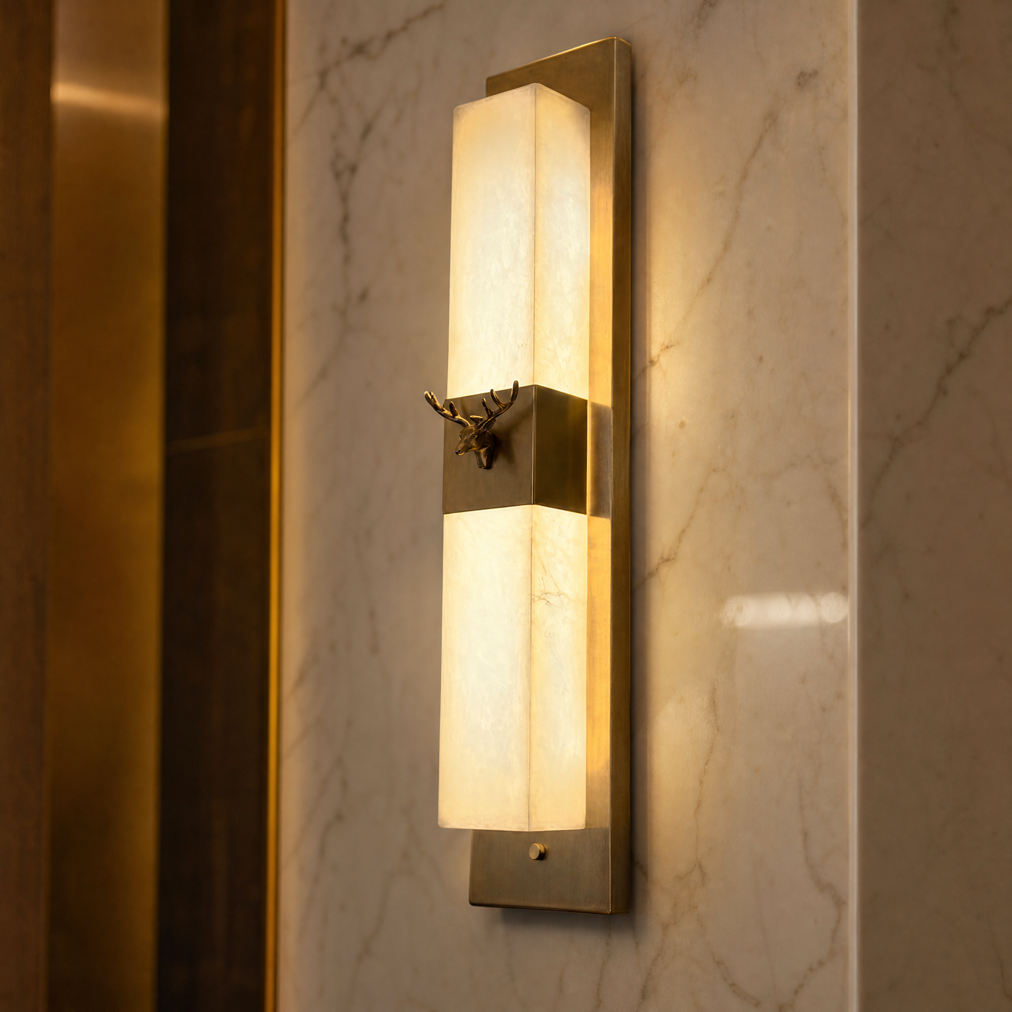 Macro closeup shot of the VORELLI Cervo wall light showcasing the rich texture of natural marble and polished stainless steel stag craftsmanship.