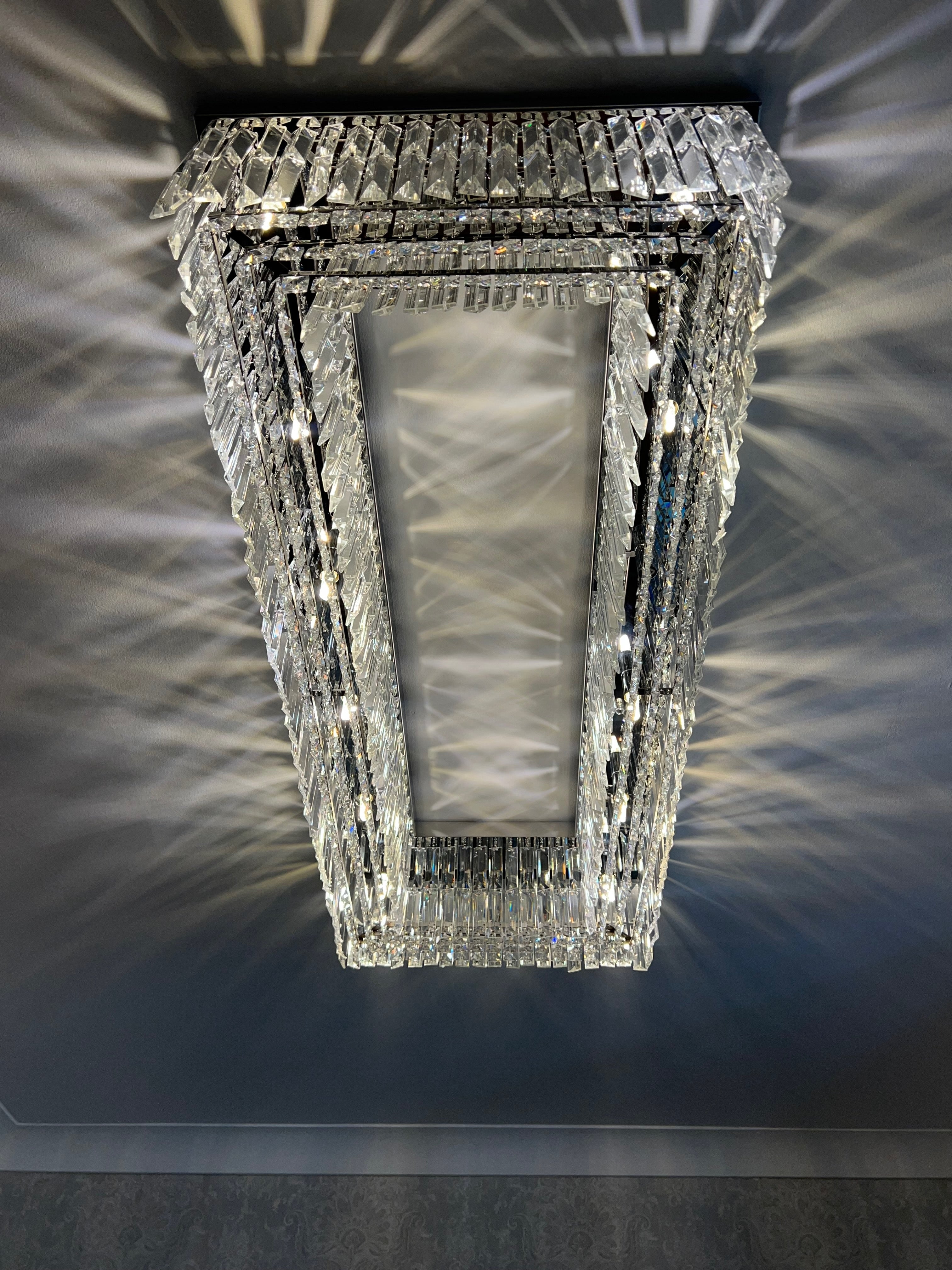Rectangular crystal ceiling light with faceted crystals creating an elegant light pattern in a luxury interior