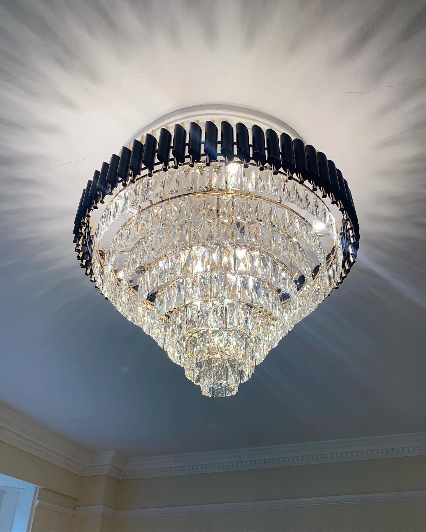Luxury crystal chandelier by VORELLI® enhancing a refined entrance hallway with warm architectural lighting.