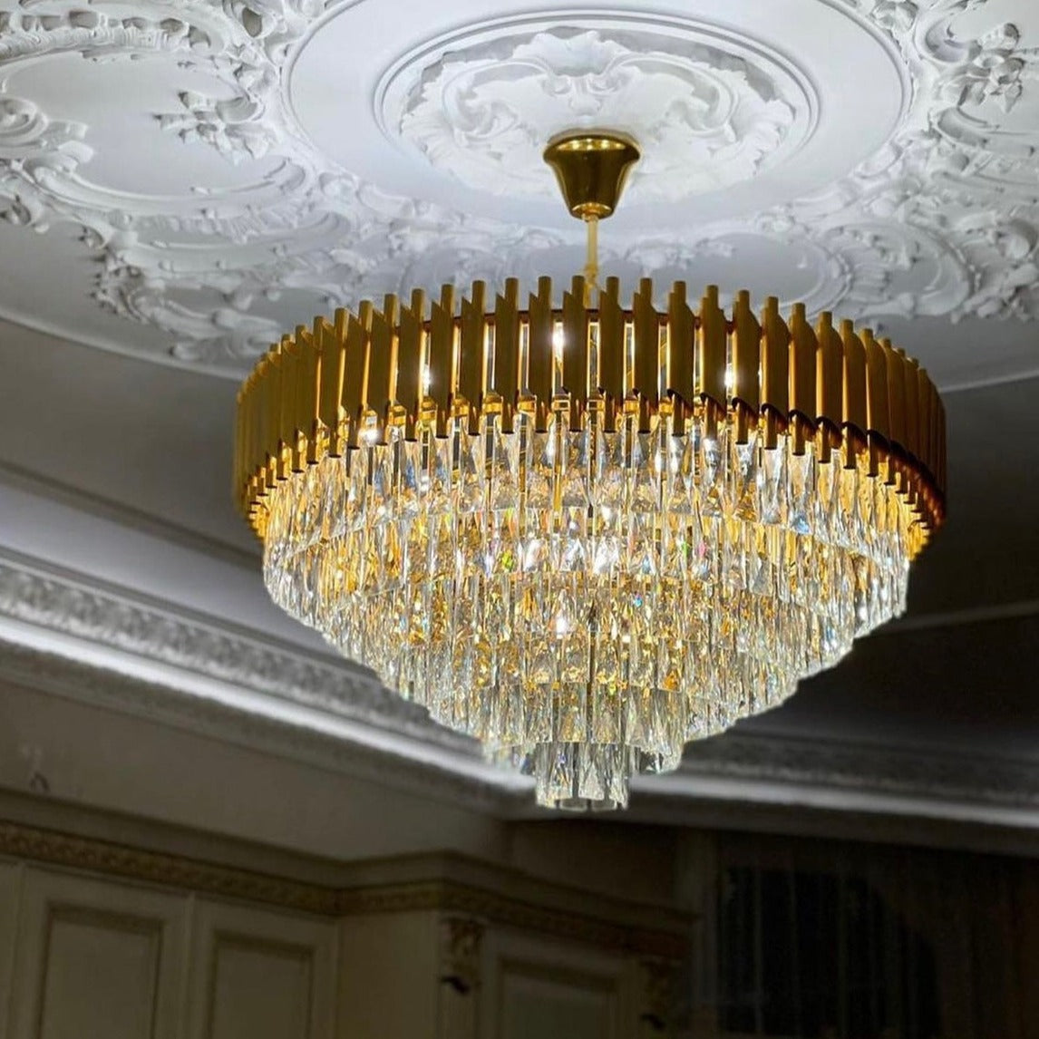 Luxury crystal chandelier by VORELLI® paired with decorative ceiling detailing in a premium interior.