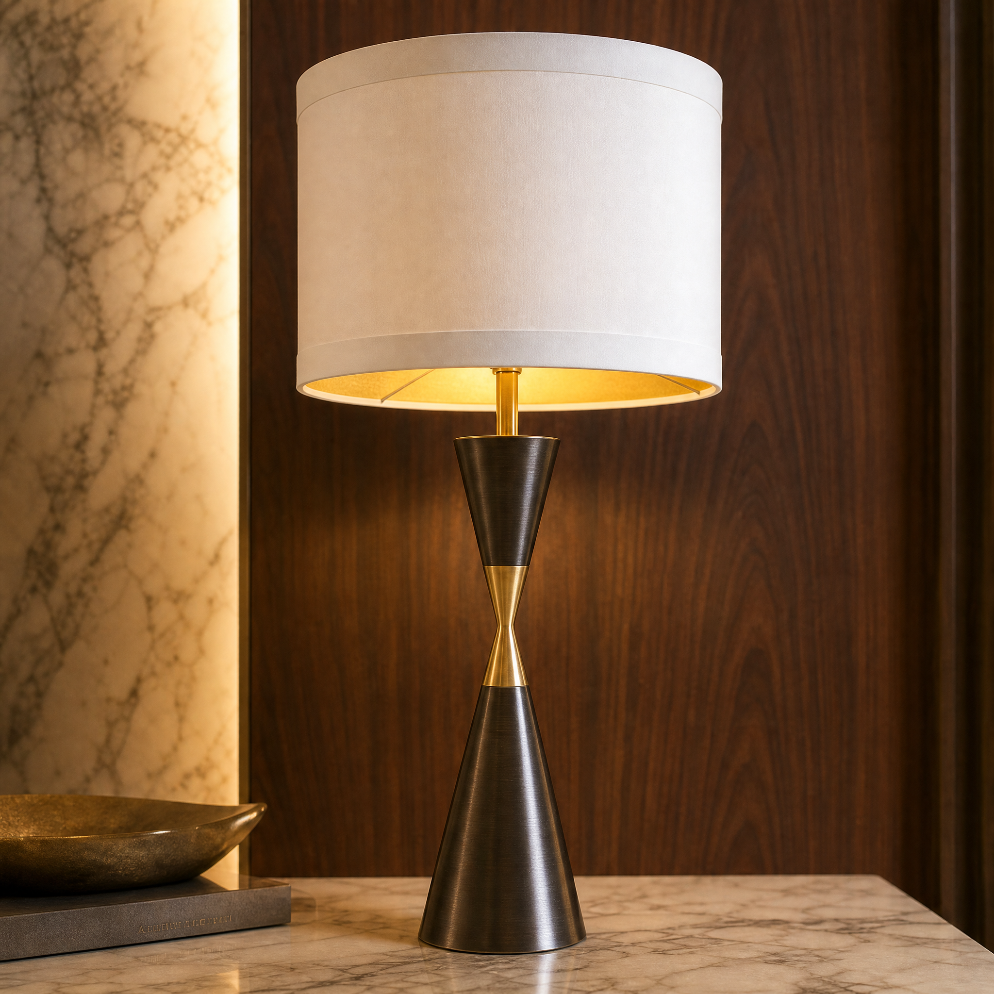 A detailed close-up shot highlighting the refined contrast detailing and rich texture of the Dalmora lamp's dark brushed brass tapered geometric base.