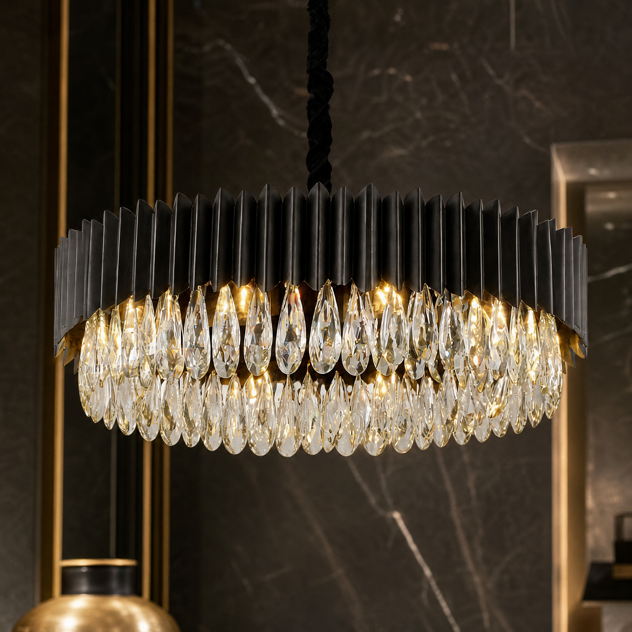 Macro closeup of the VORELLI Doral chandelier showcasing the intricate diamond-cut teardrop crystals and unique circular design framework.