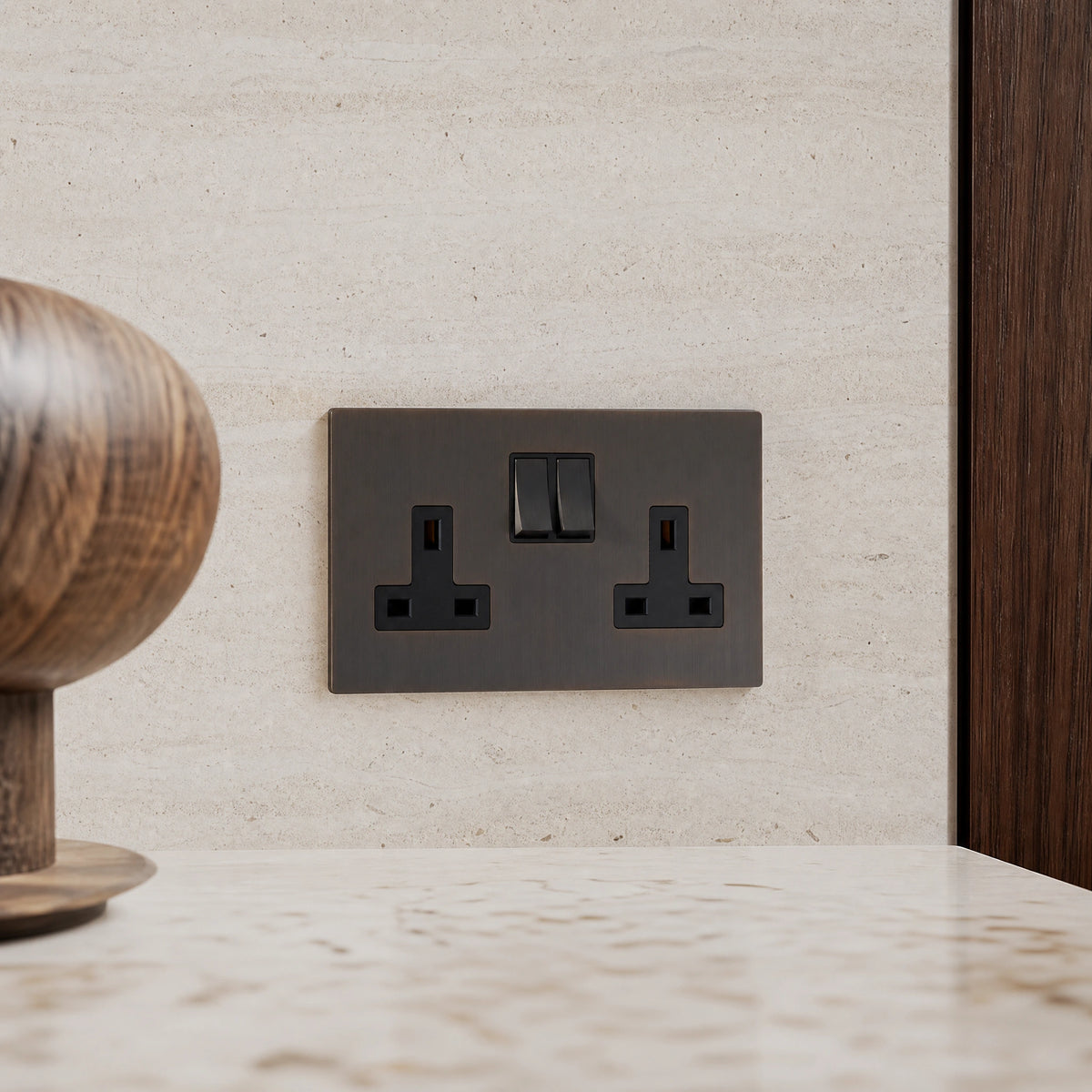 Close-up of a luxury sienna double socket installed within bespoke walnut cabinetry or stone worktop in a luxury residence by VORELLI®.